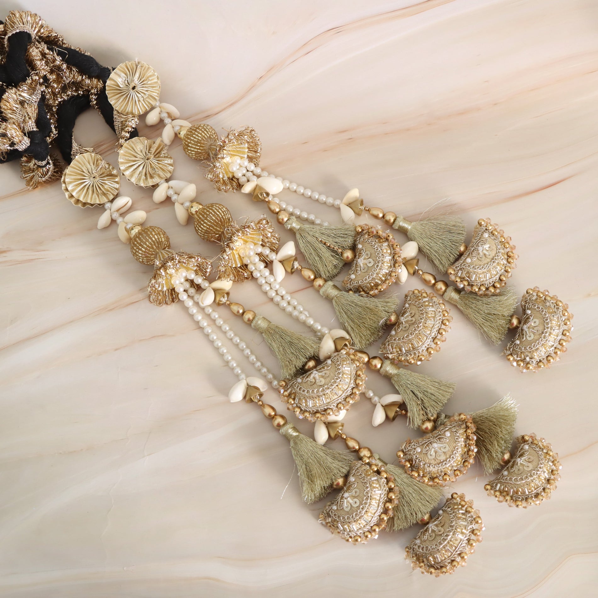 Decorative hair accessory with gold and green elements on a marble surface