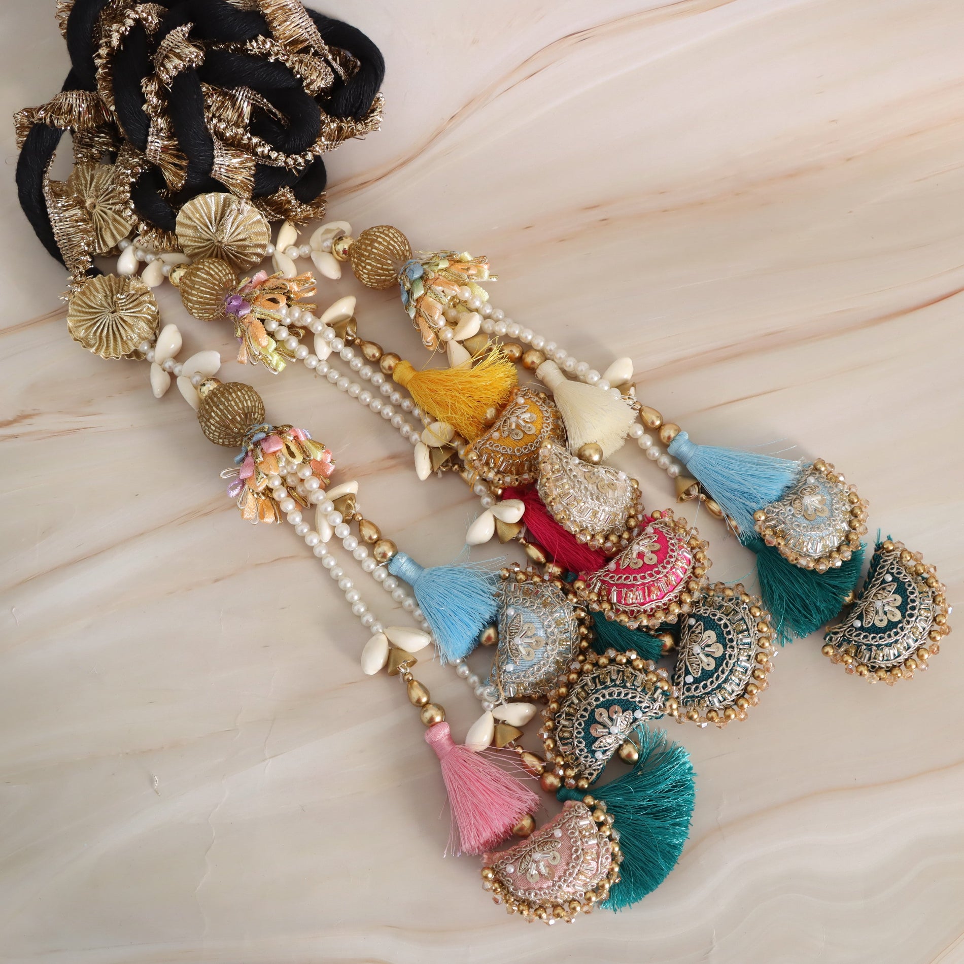 Colorful decorative hair accessory with tassels on a light wooden surface