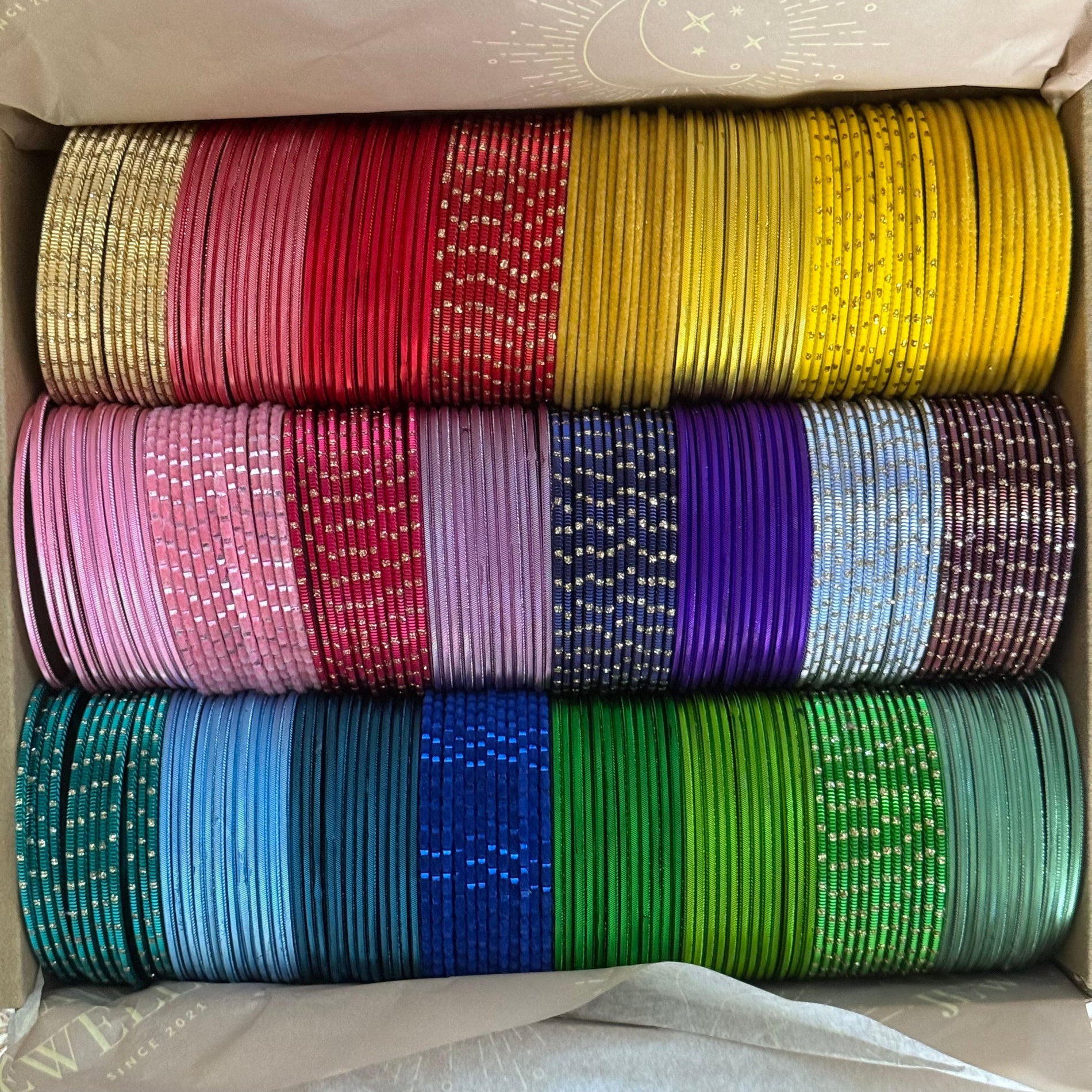 Box containing colorful bangles stacked in rows.