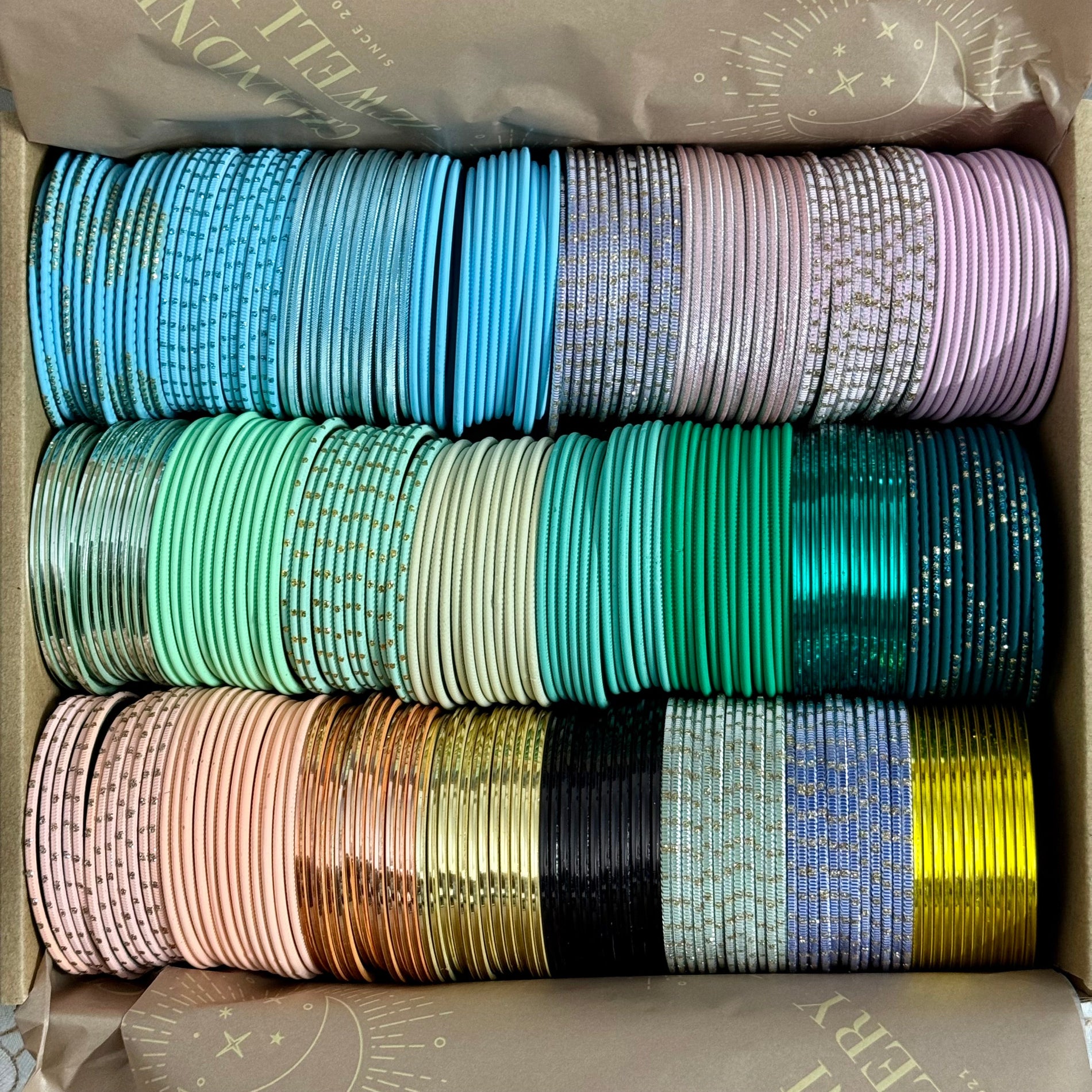 Box containing multiple rolls of colorful bangles.