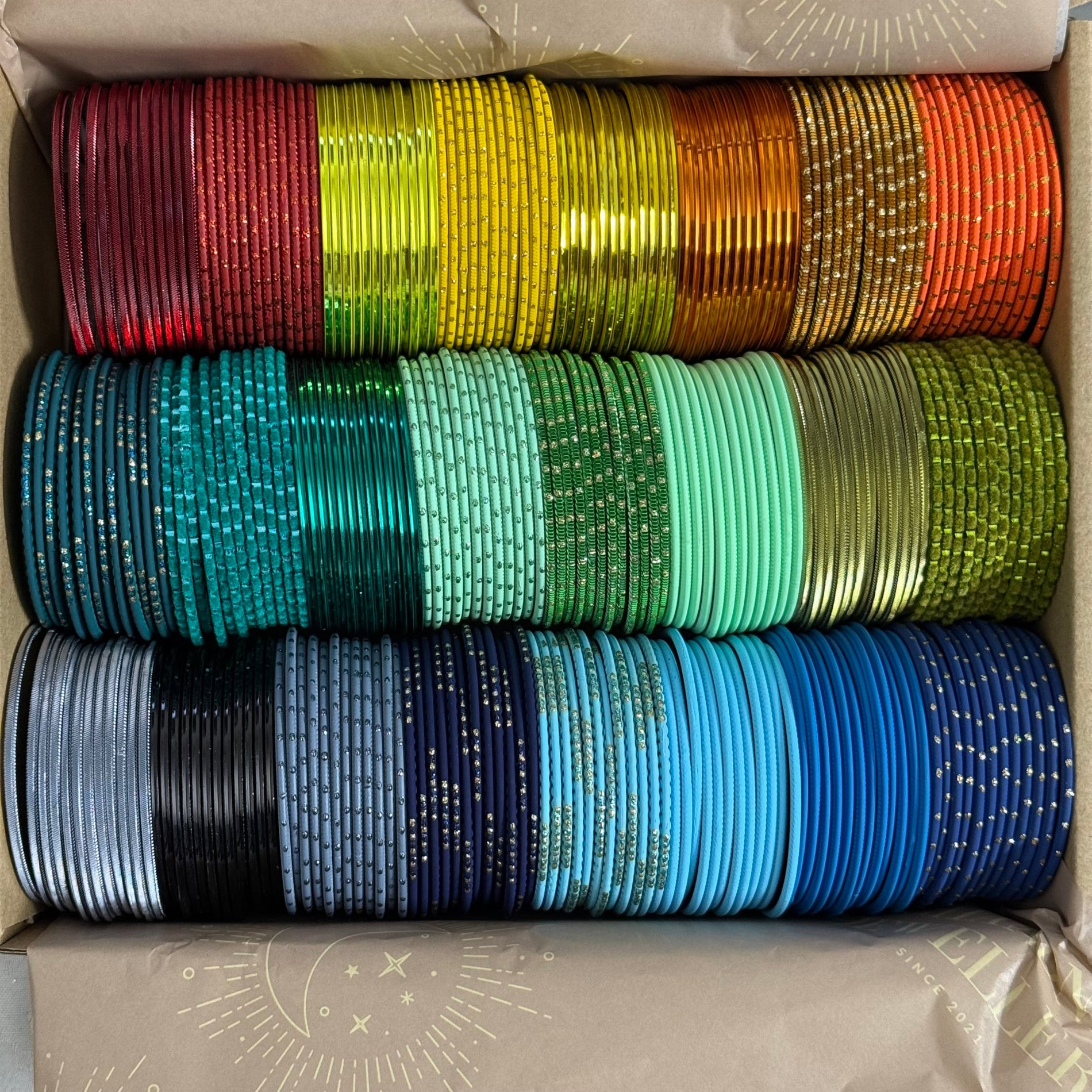 Box containing colorful bangles stacked in rows.