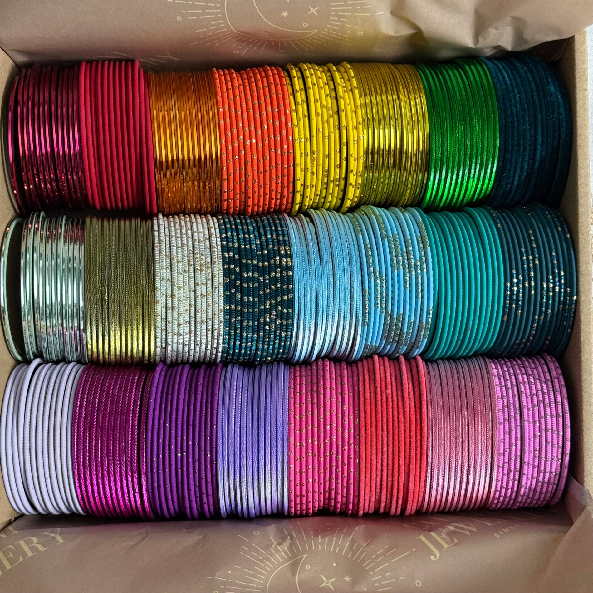 Box filled with colorful bangles stacked in rows.