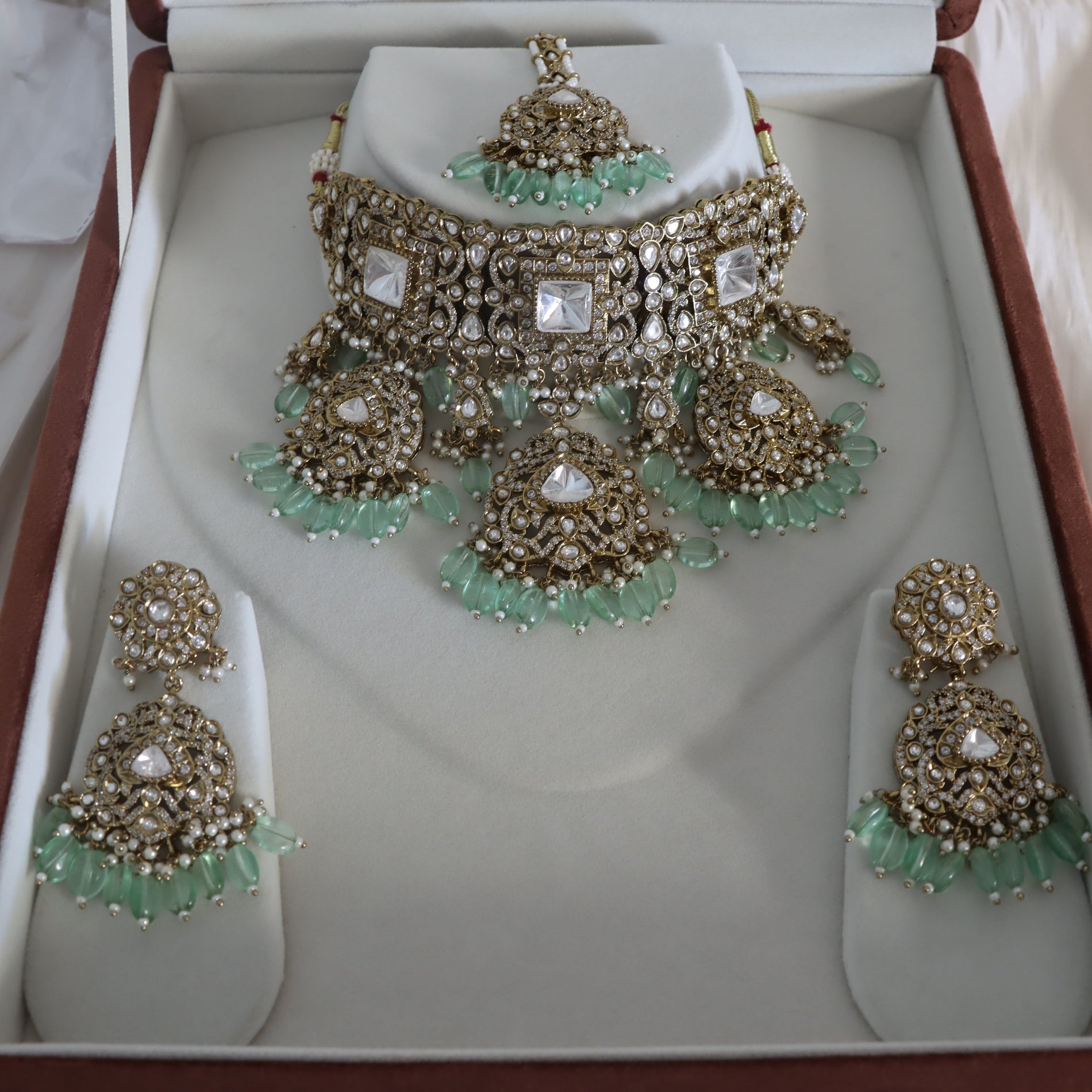 Jewelry set with necklace and earrings on a white display stand