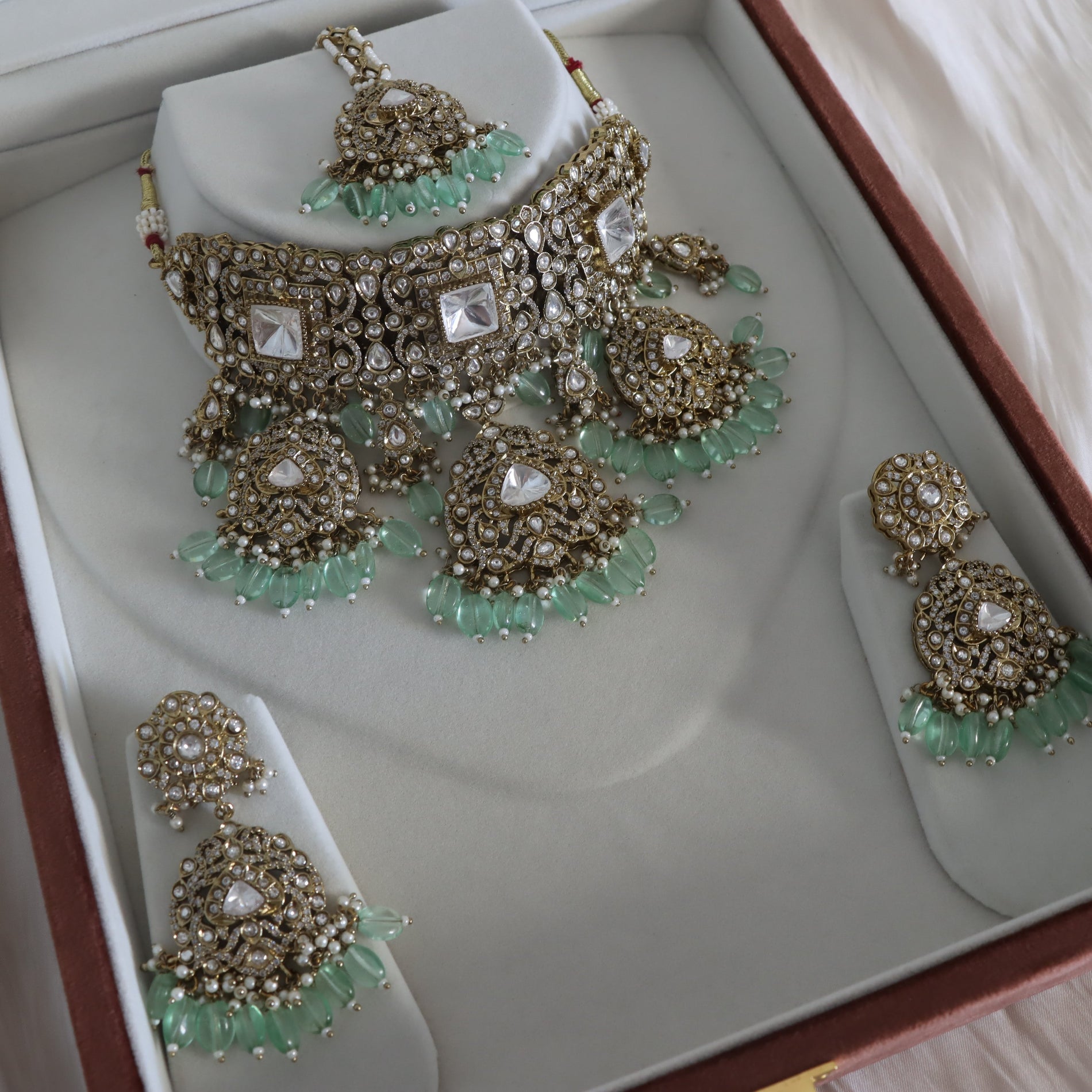 Jewelry set with necklace and earrings on a white stand