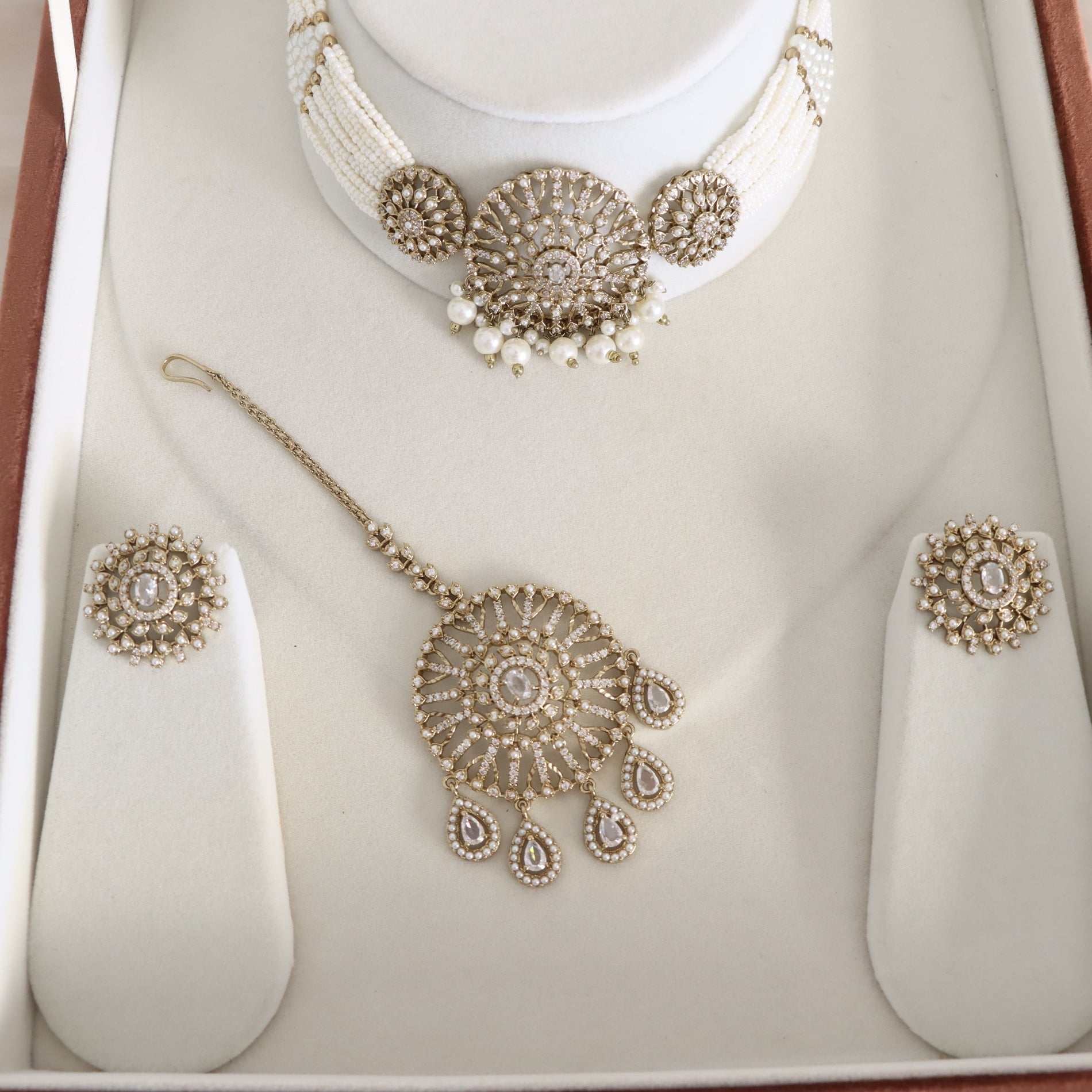 Jewelry set including necklace, earrings, and possibly rings on a white surface.
