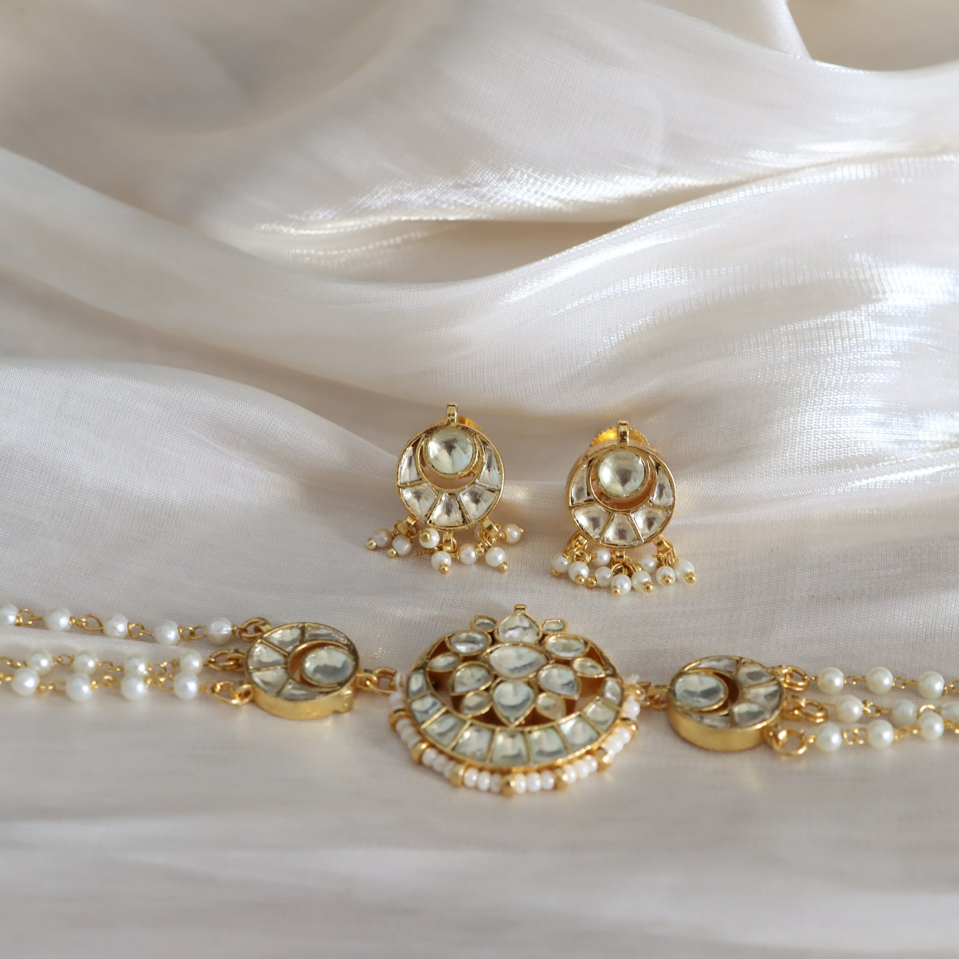 Jewelry set with necklace and earrings on a white fabric background