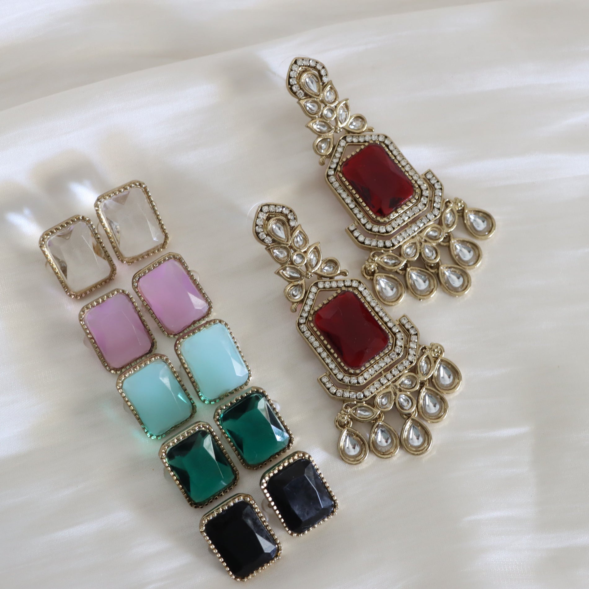 Colorful square gemstone earrings with gold accents on a white background