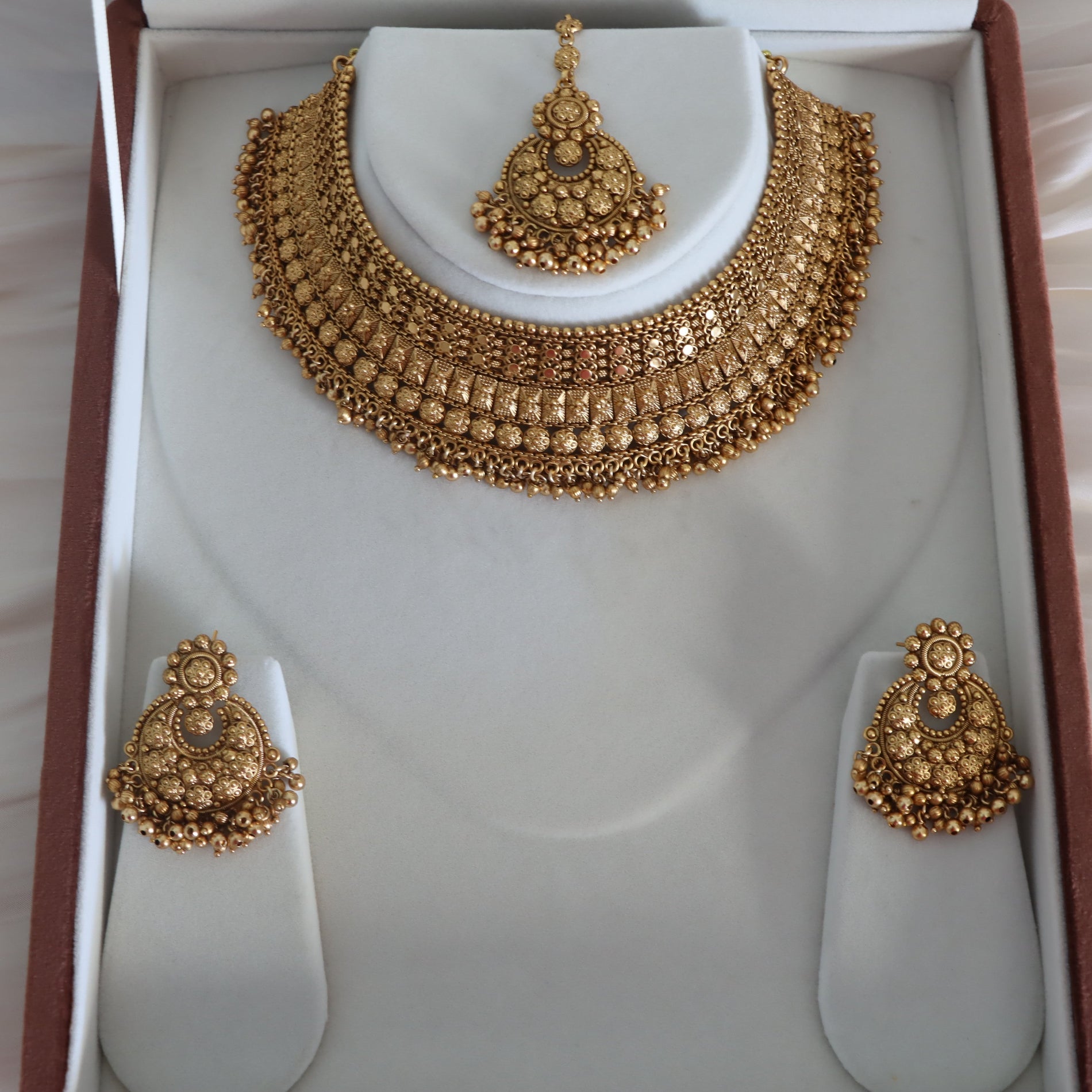Gold necklace and earrings set in a jewelry box