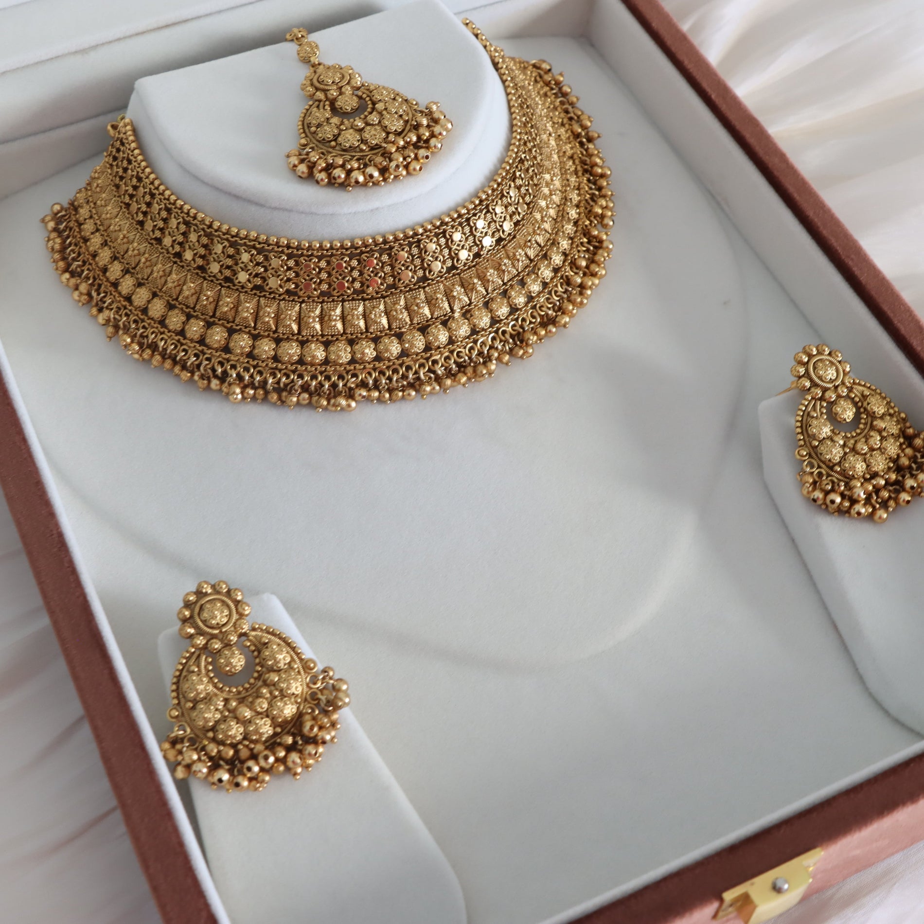 Gold necklace and earrings set in a jewelry box