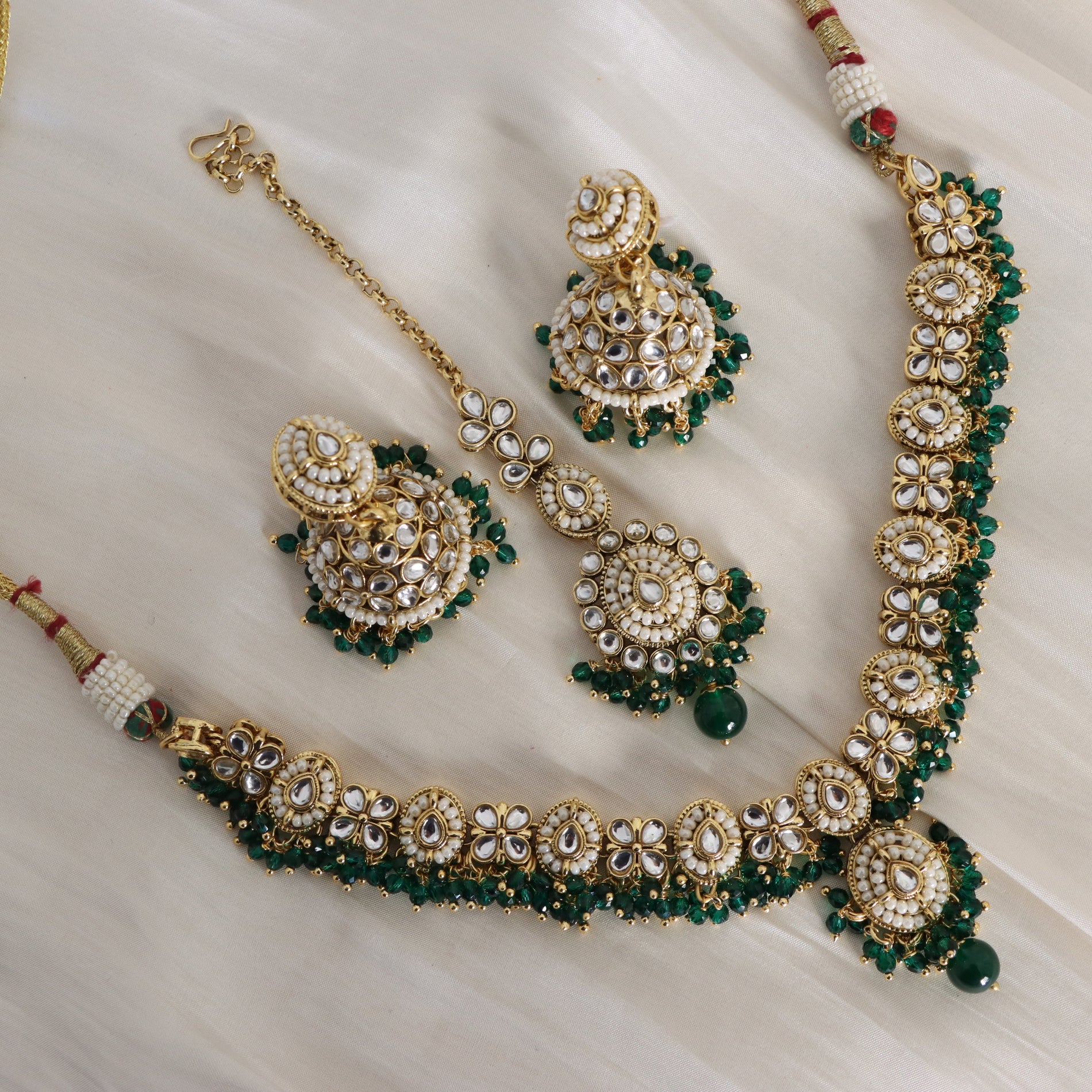 Jewelry set with necklace, earrings, and bracelet on a light background