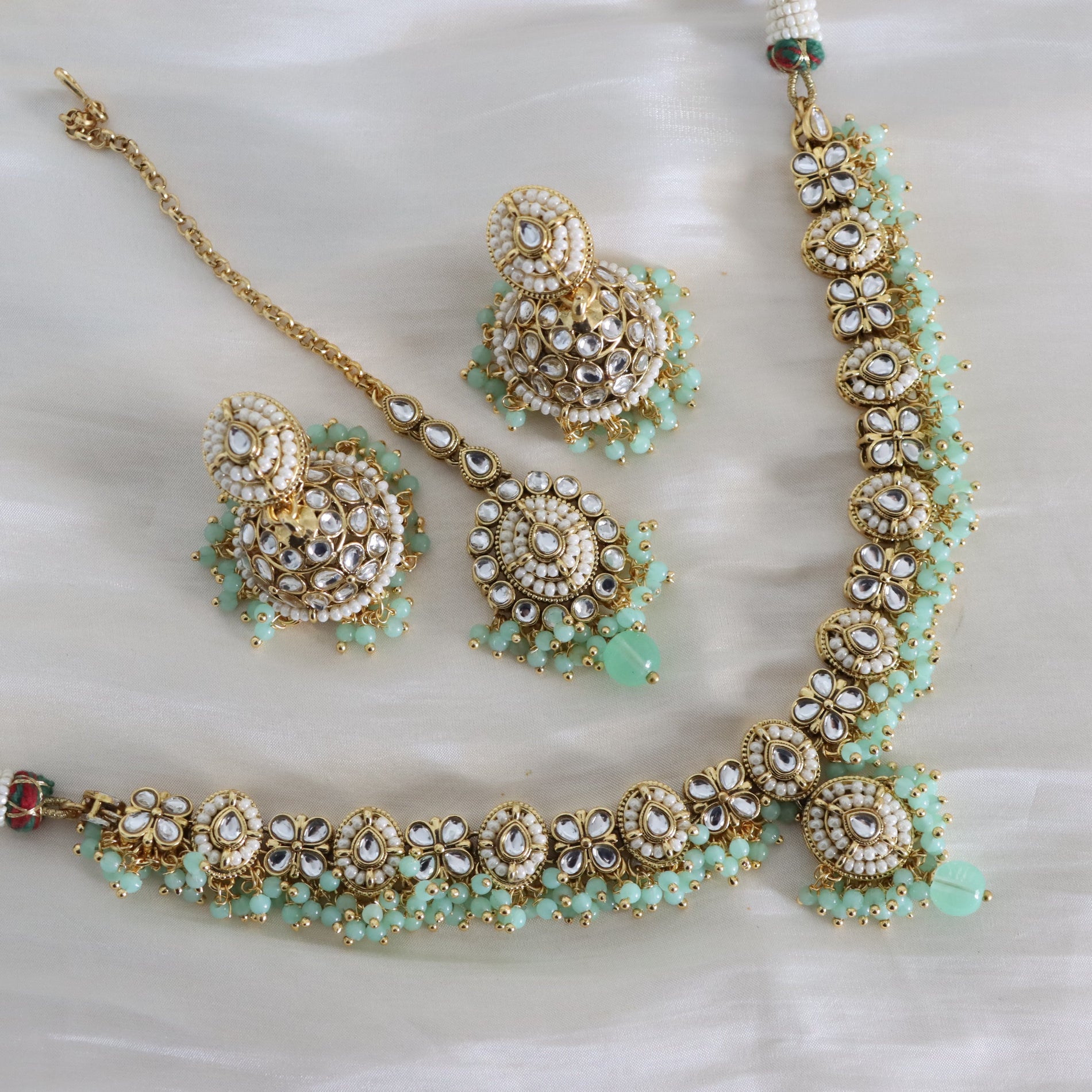 Jewelry set with necklace, earrings, and bracelet on a white background