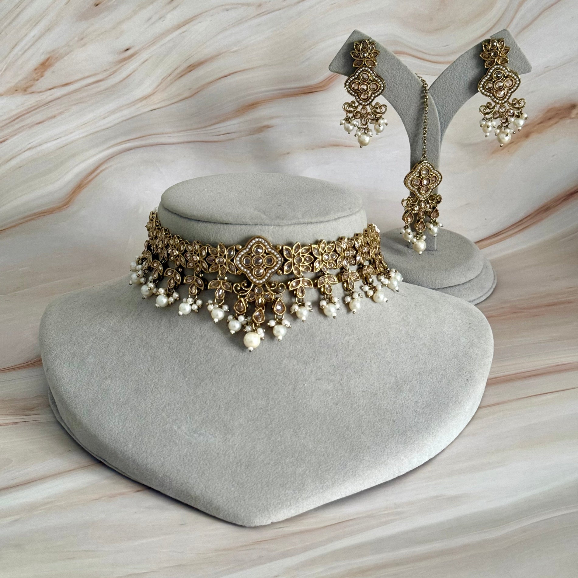 Jewelry set with necklace and earrings on a marble surface