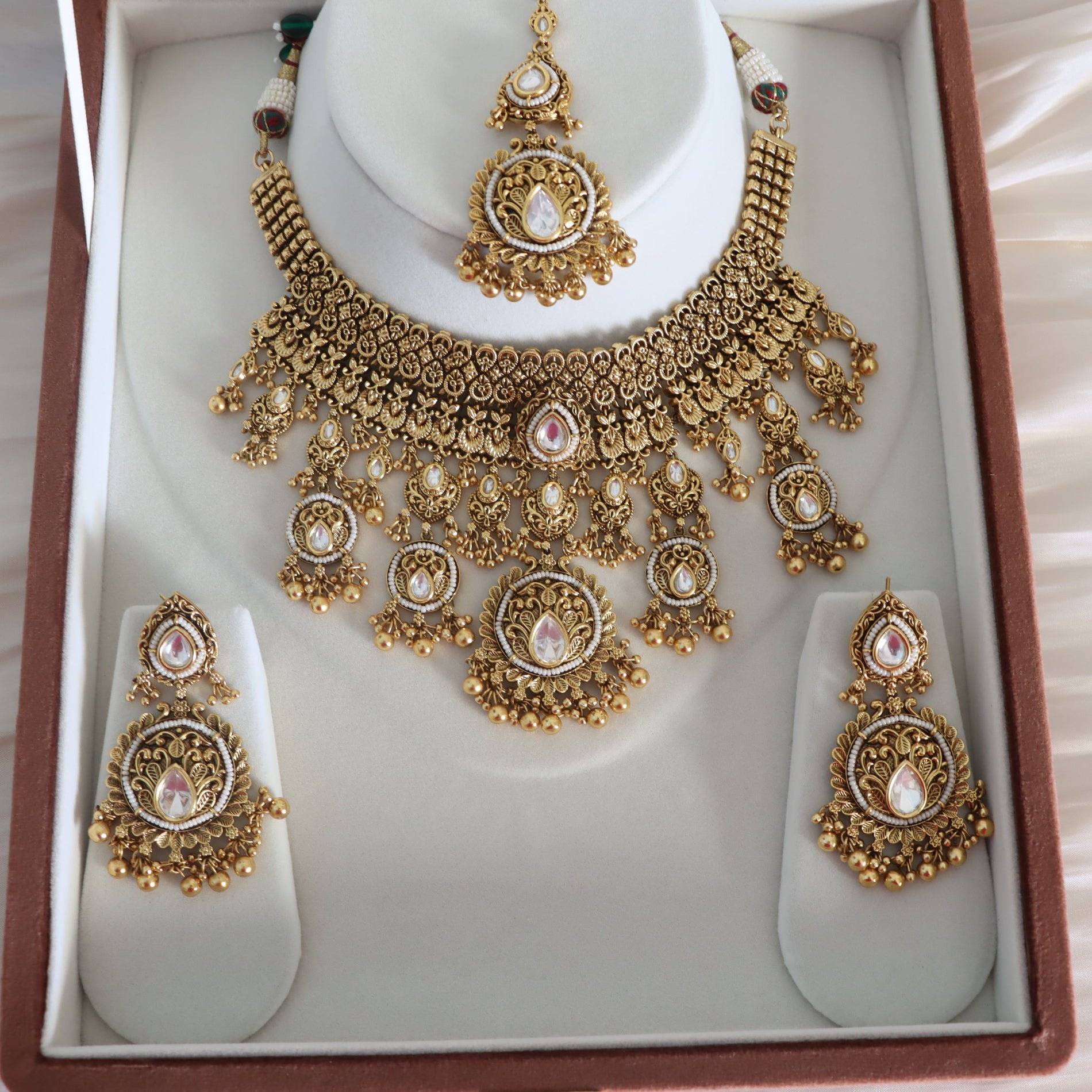 Gold necklace and earrings set in a jewelry box