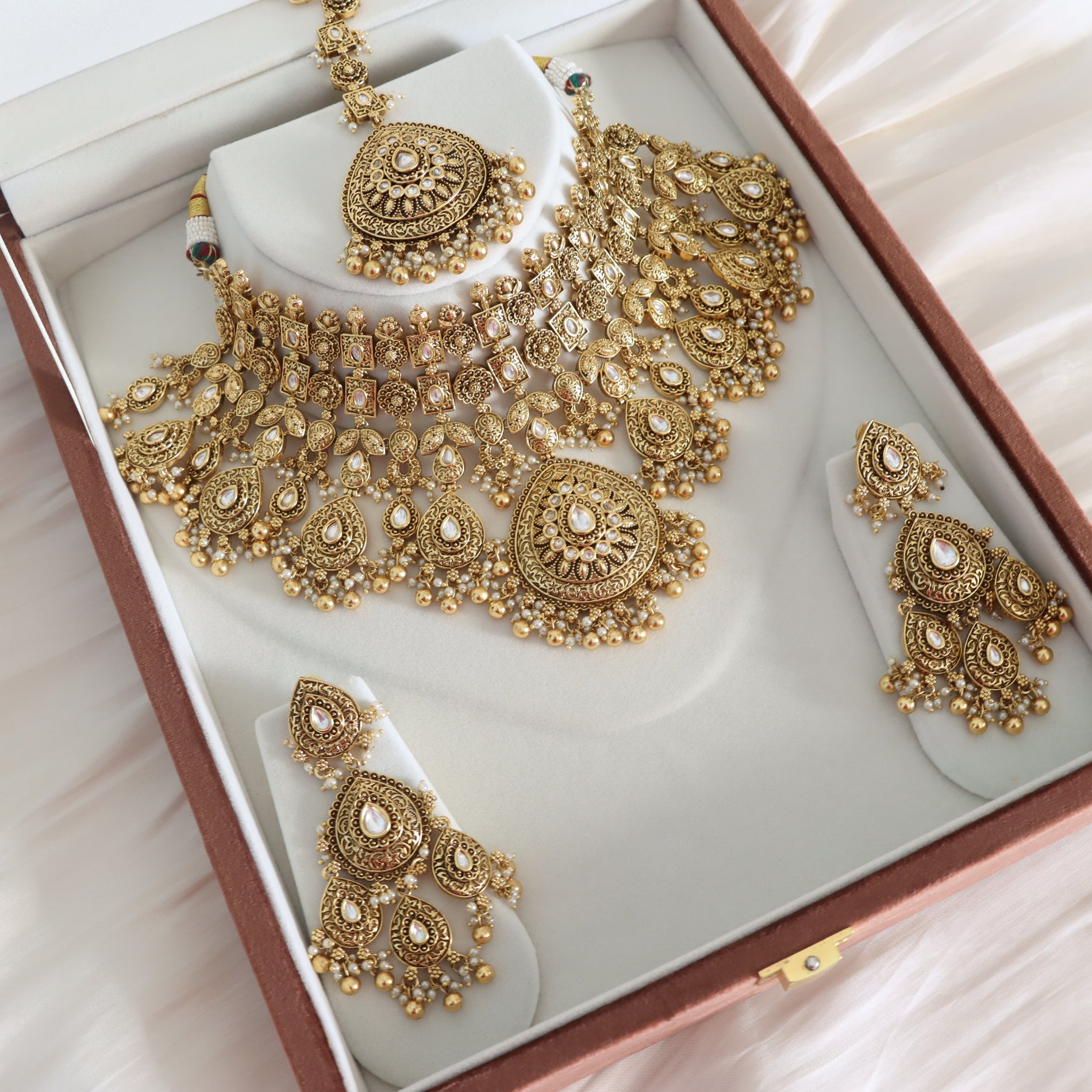 Gold jewelry set including necklace and earrings in a box