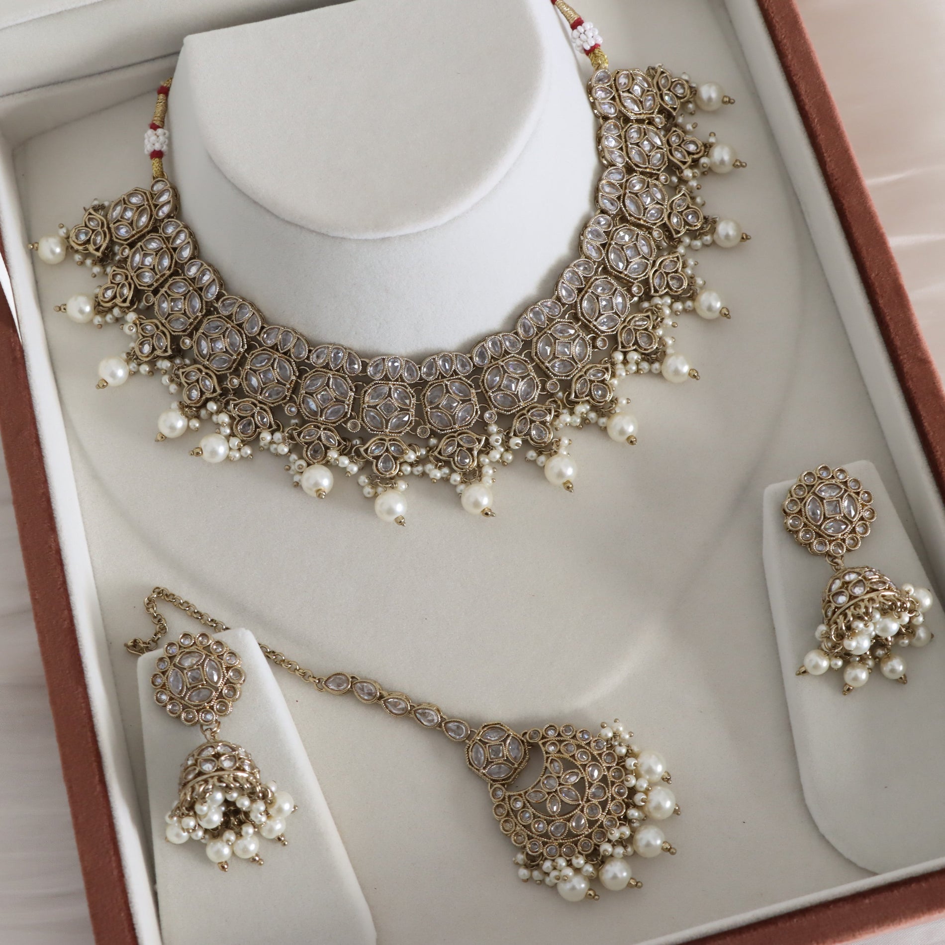 Jewelry set with necklace, earrings, and choker on a mannequin bust.