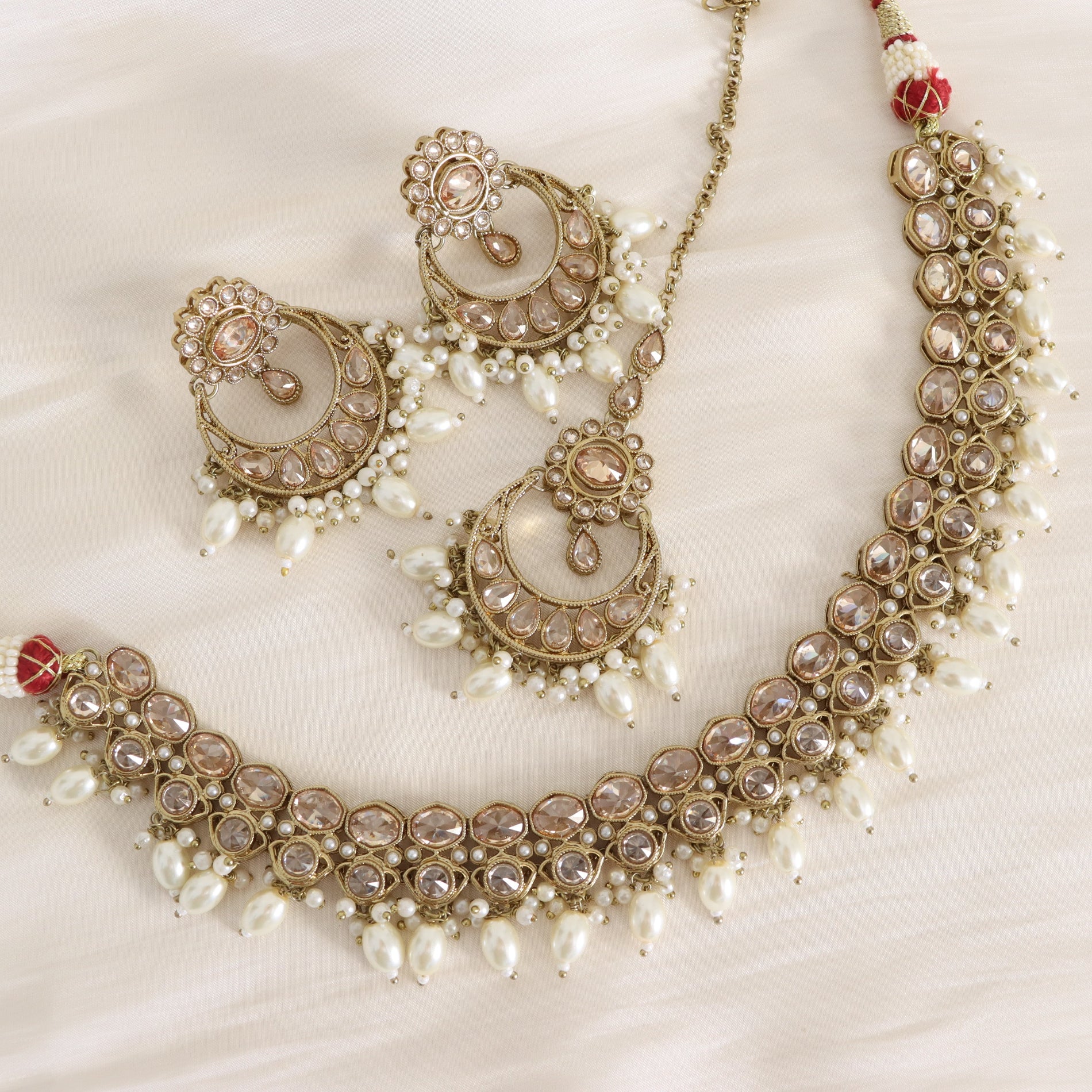 Ornate necklace with pearl-like beads on a white background