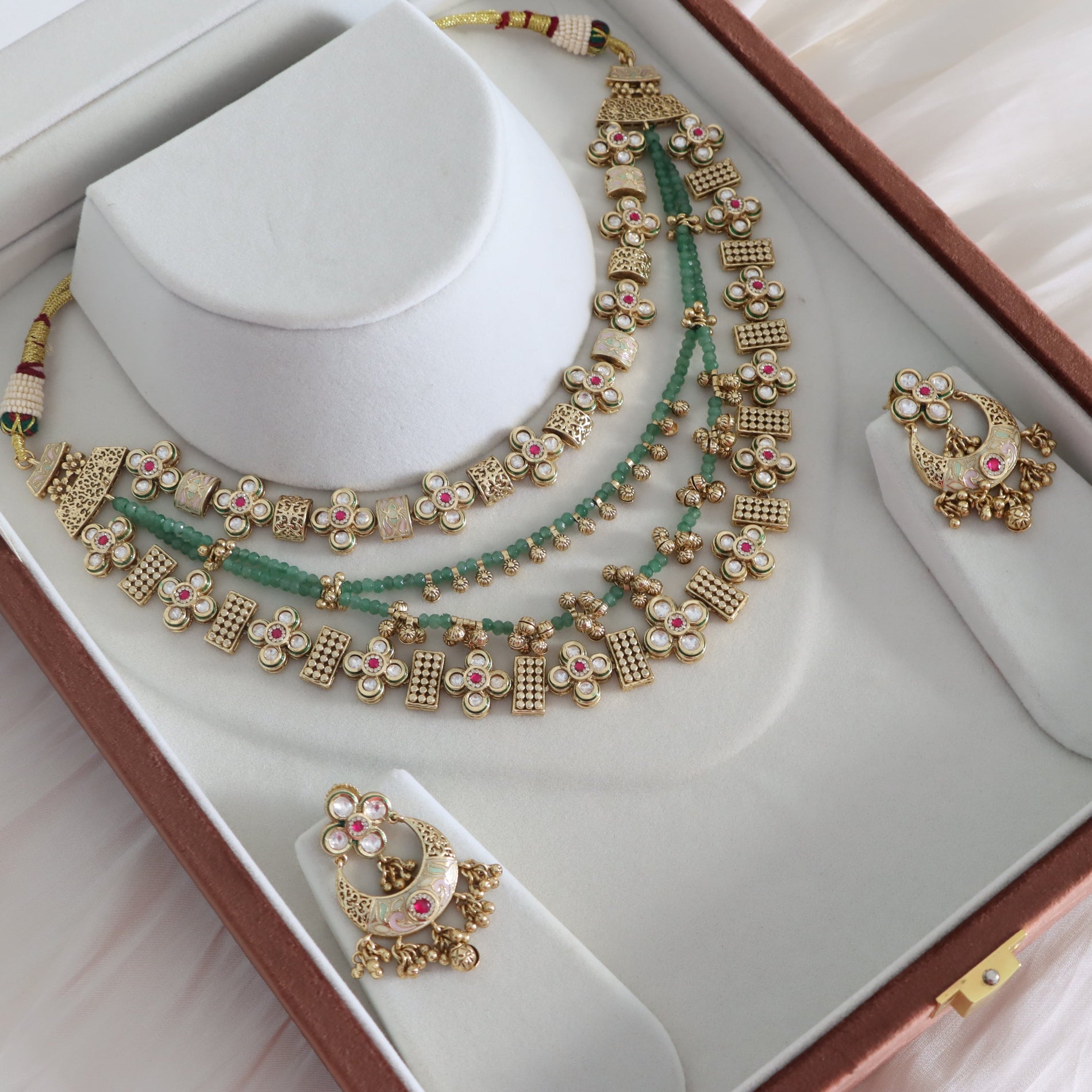 Jewelry set with necklace and earrings on a white stand