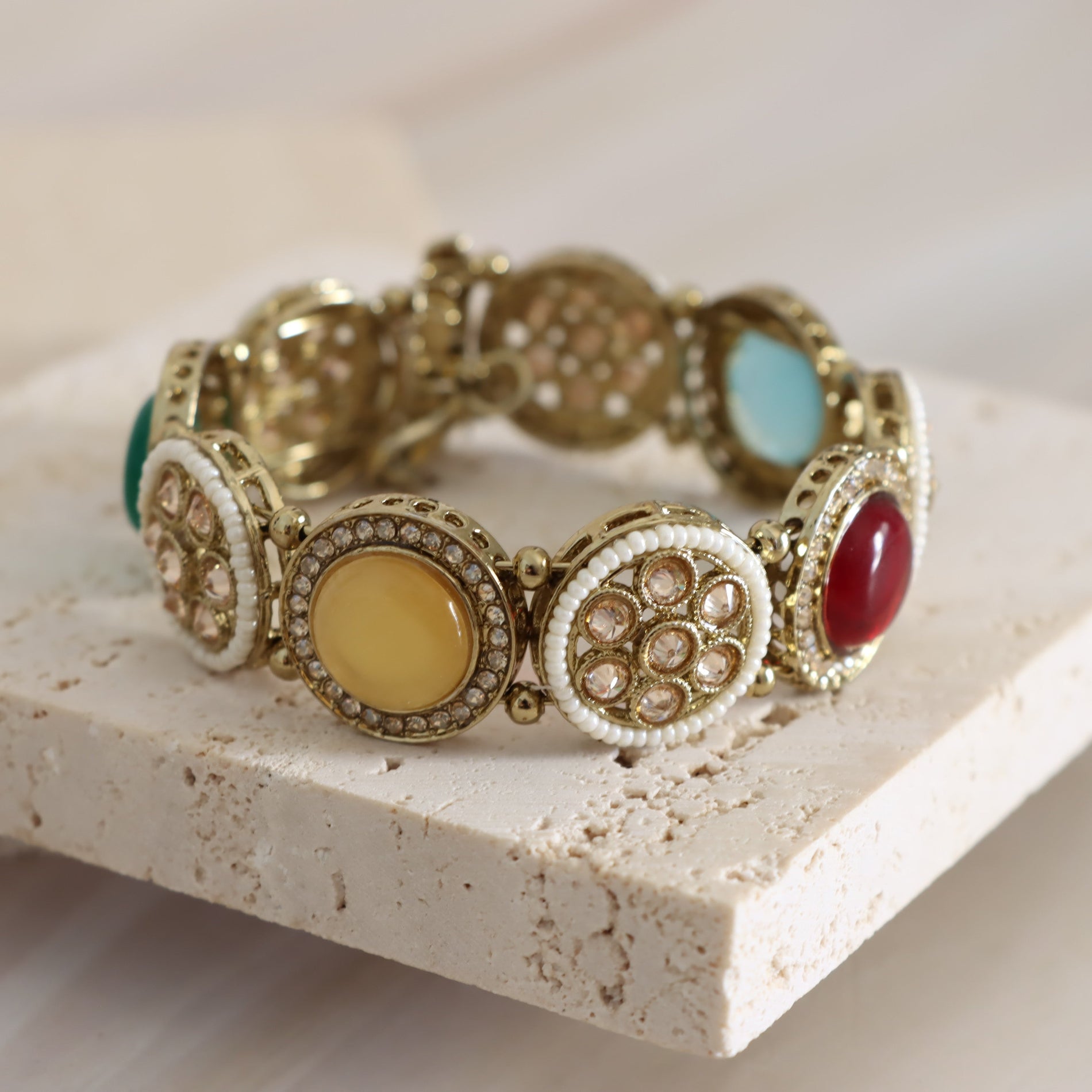 Decorative bracelet with colorful stones on a stone surface
