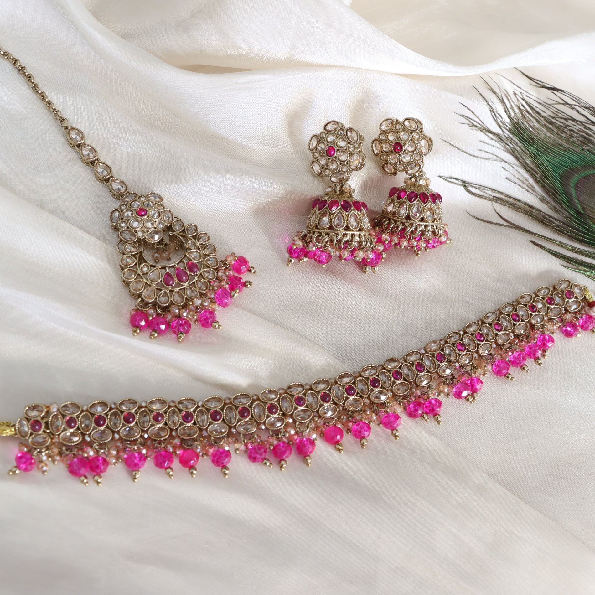 Jewelry set with necklace, earrings, and choker on a white fabric background