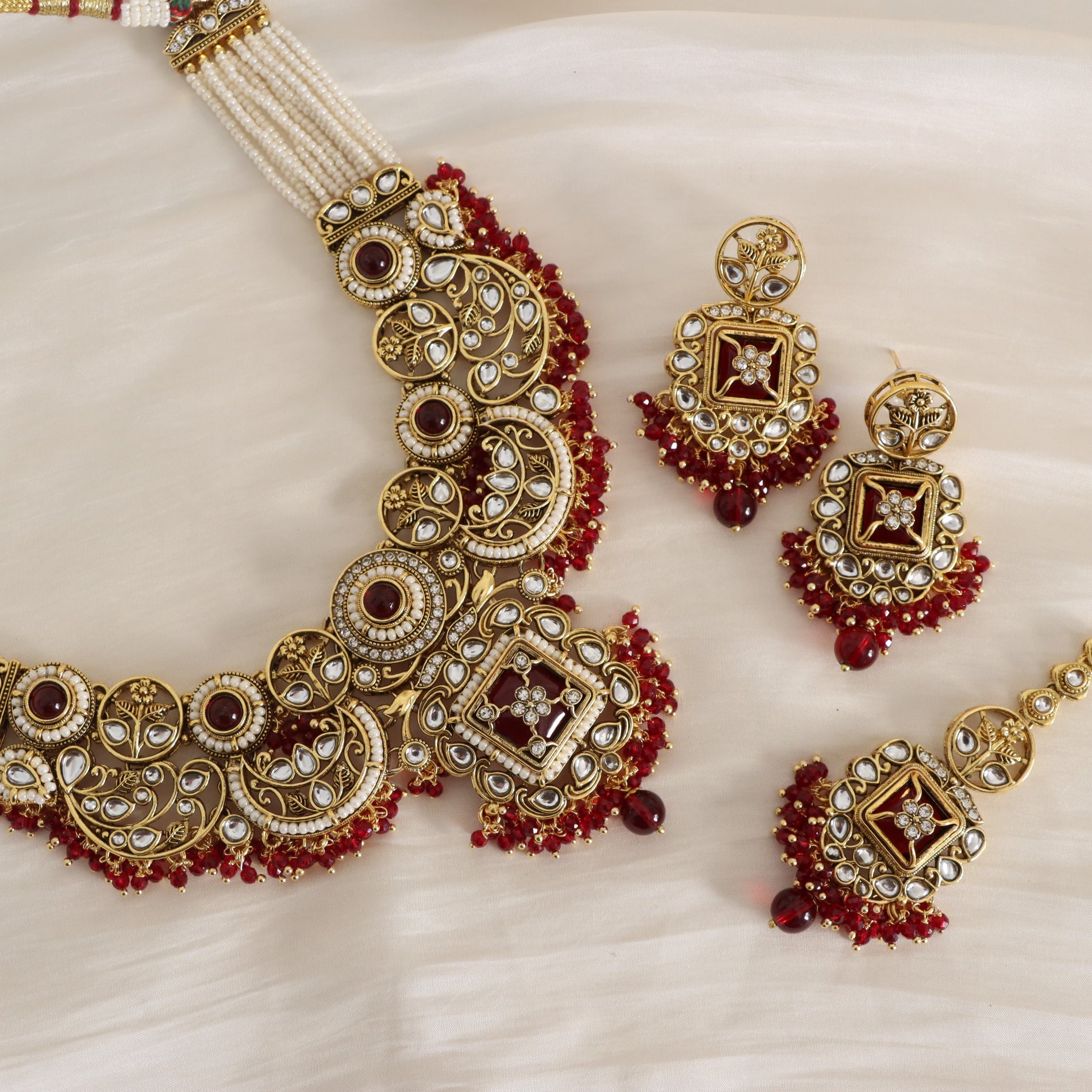 Ornate gold and red jewelry set on a light background