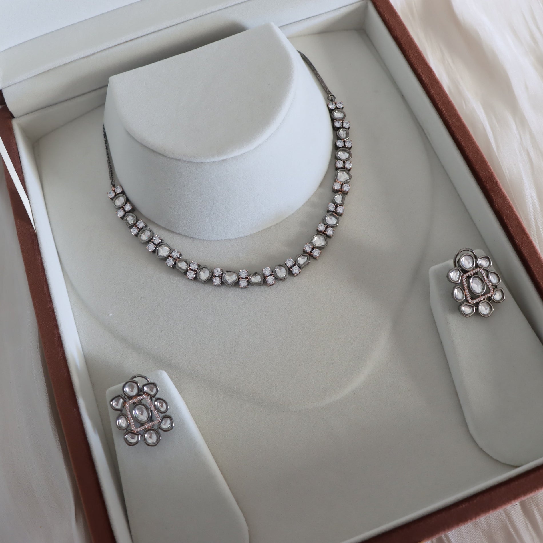 Silver necklace and earrings set in a jewelry box