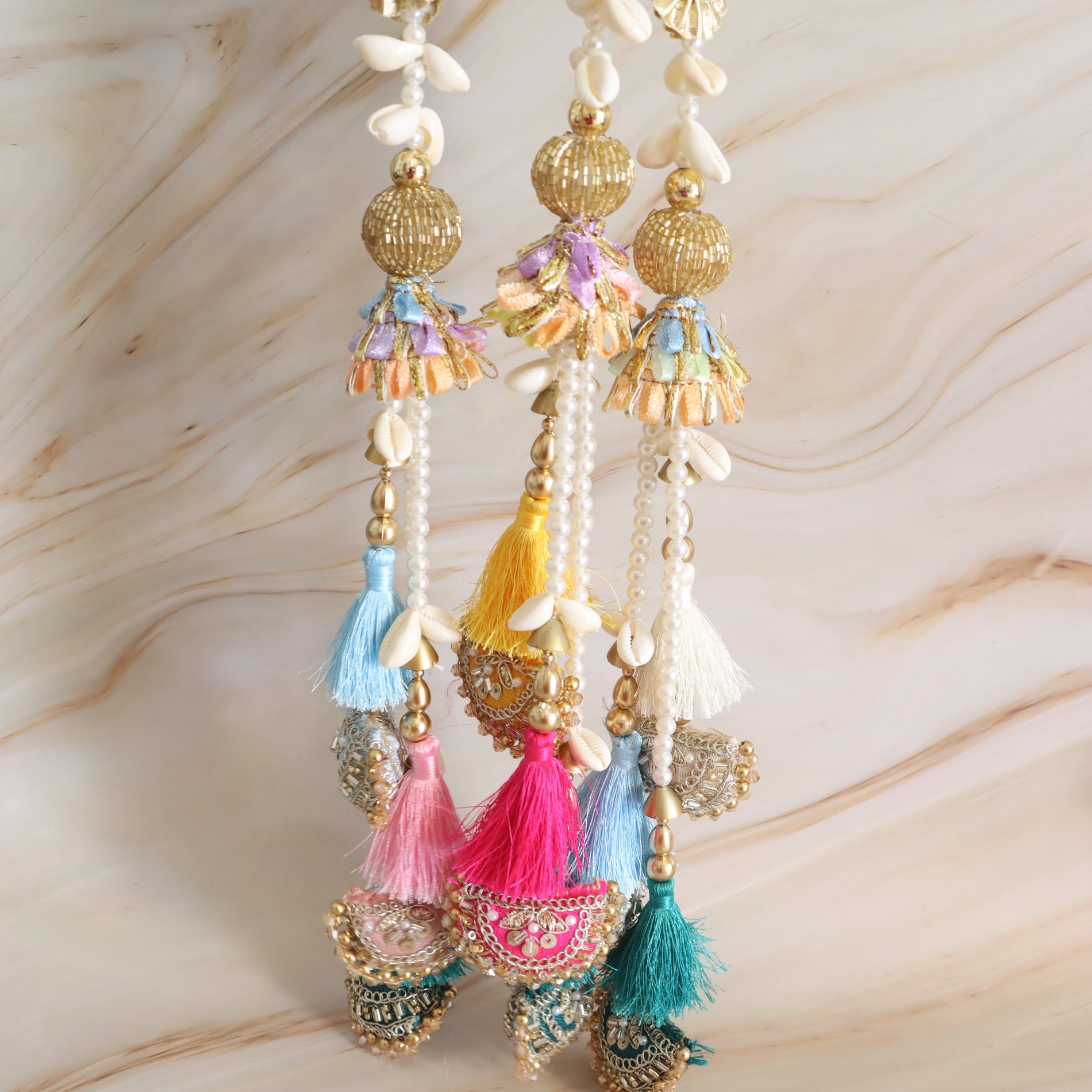Decorative hanging with tassels and beads on a marble surface