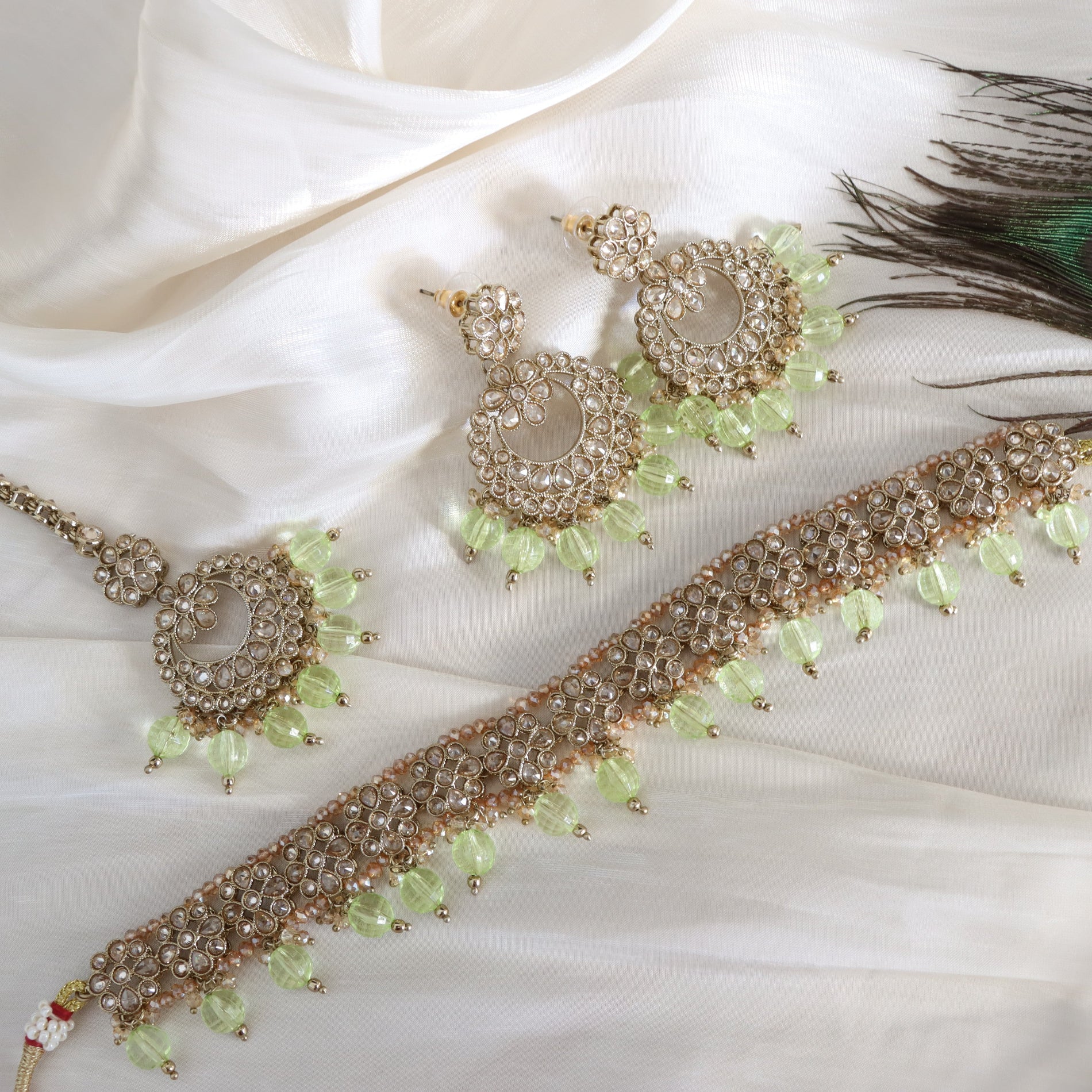 Jewelry set with necklace, earrings, and bracelet on a white fabric background