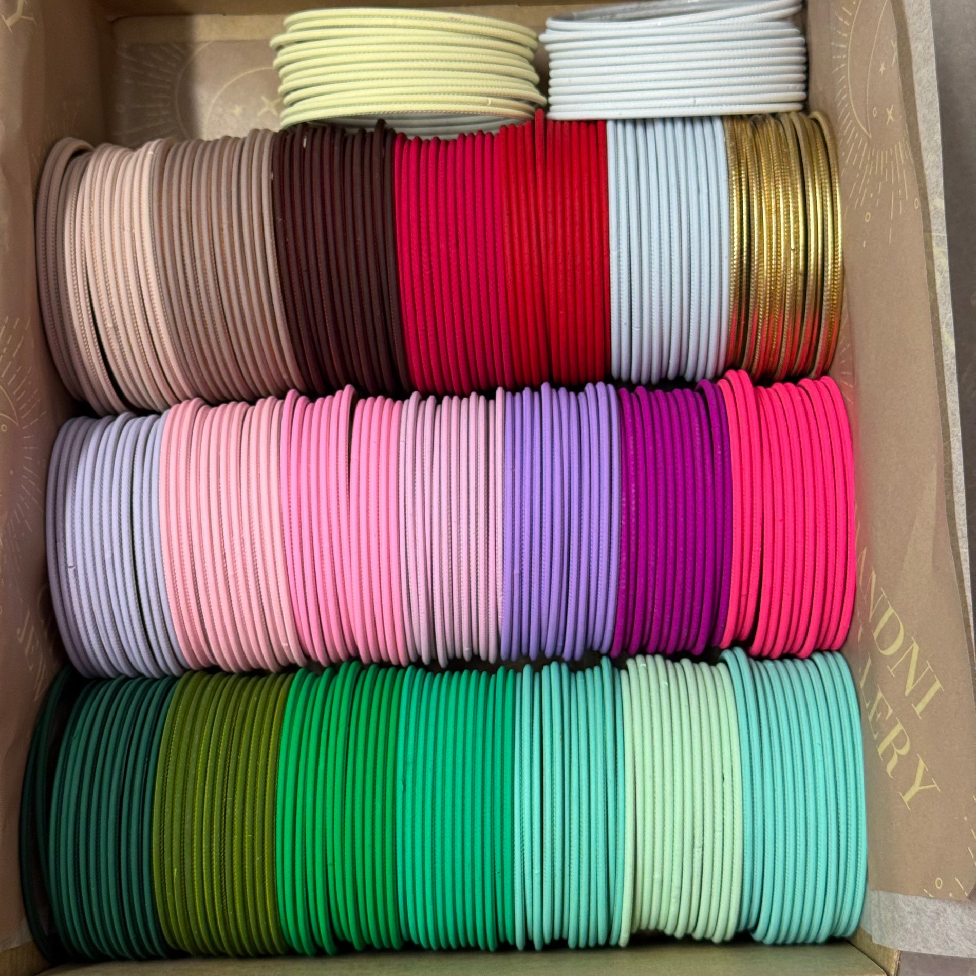 Box filled with colorful bangles in various shades.