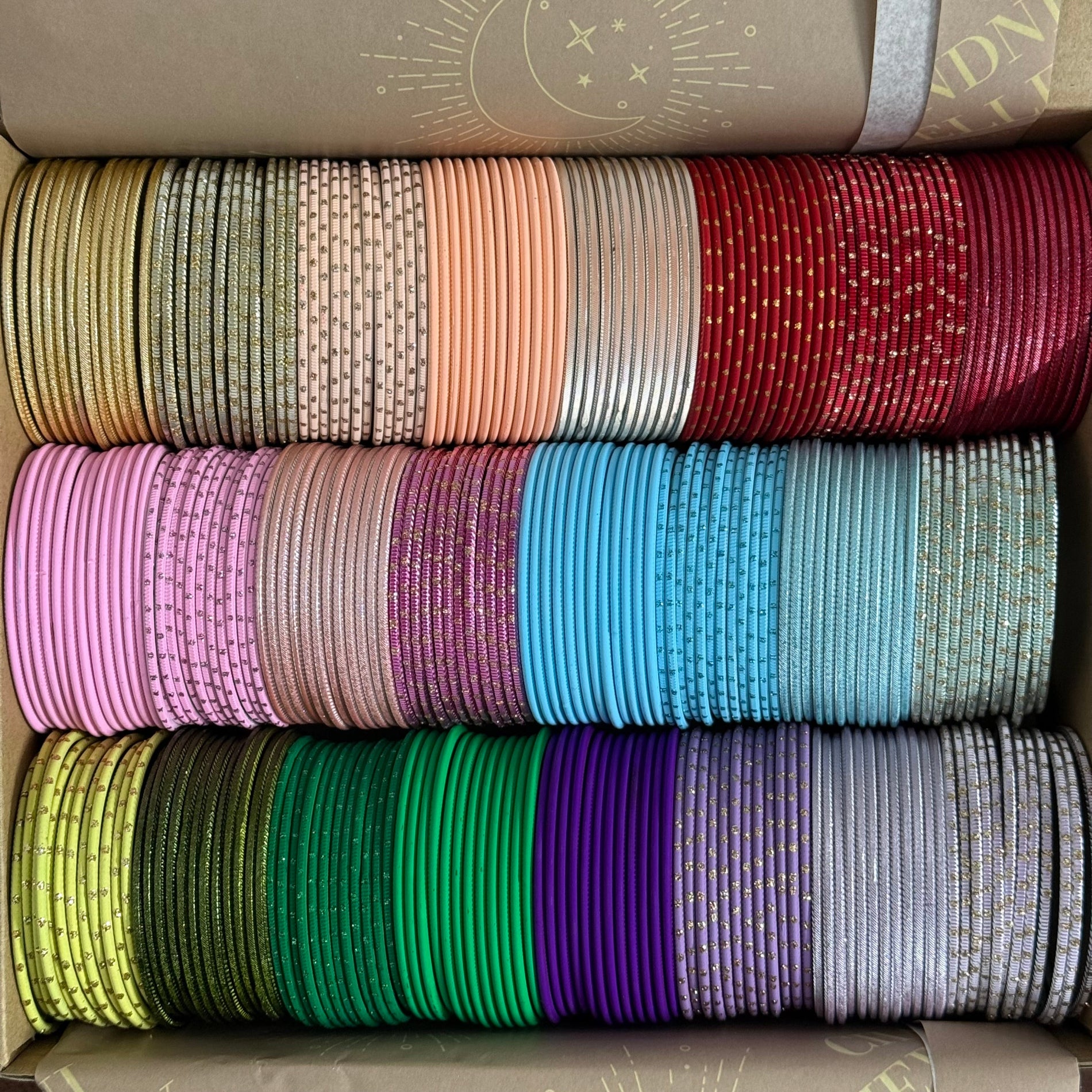 Box of colorful bangles in various patterns and colors.