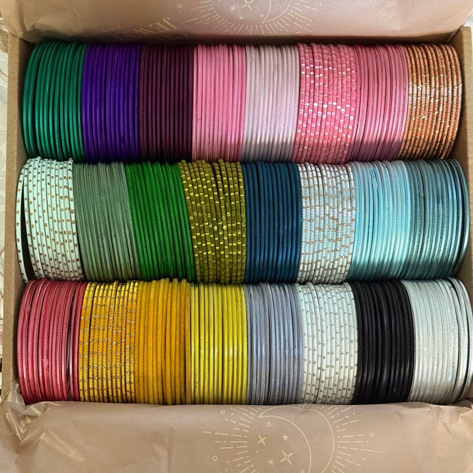 Box containing rolls of colorful bangles in various patterns