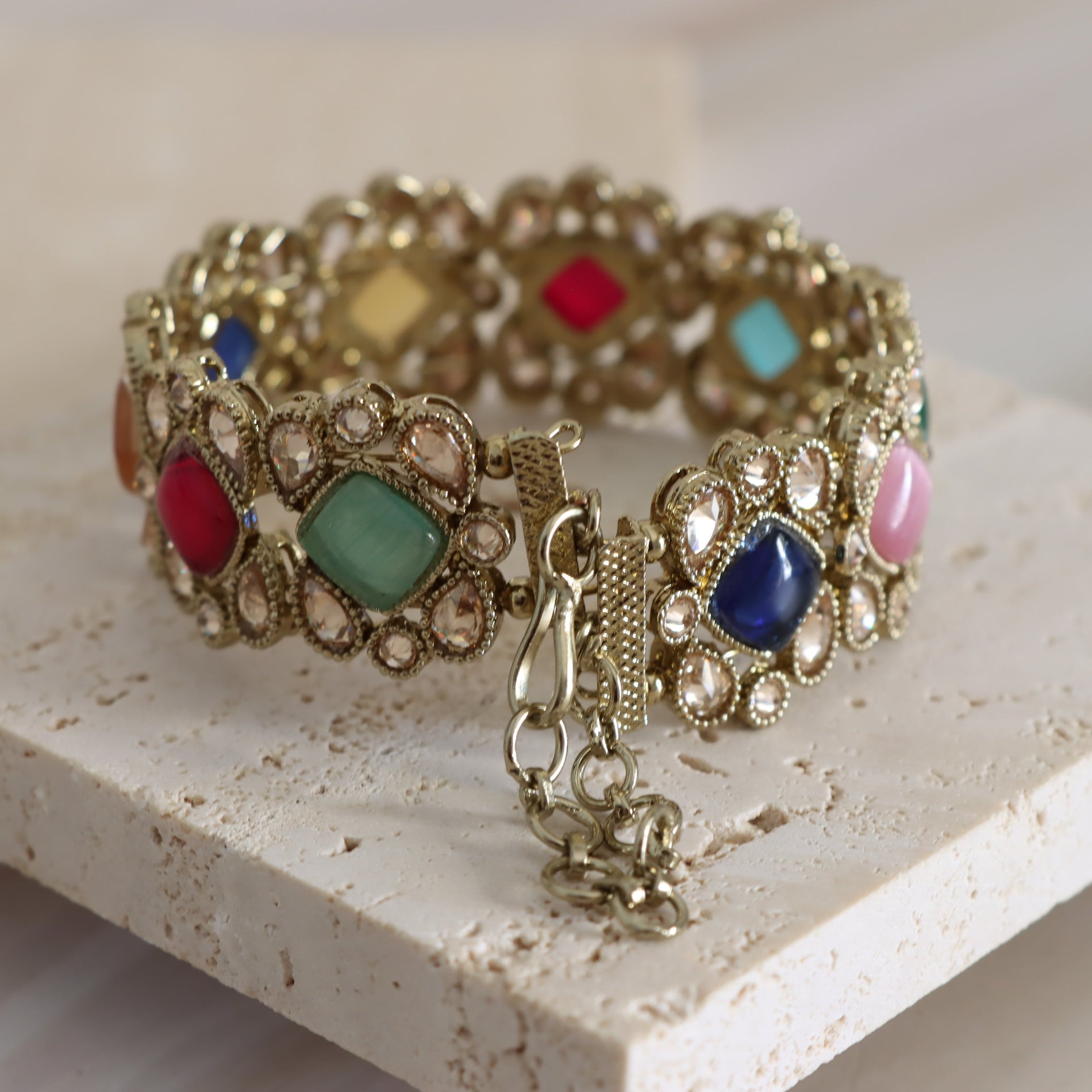 Decorative bracelet with colorful gemstones on a light surface