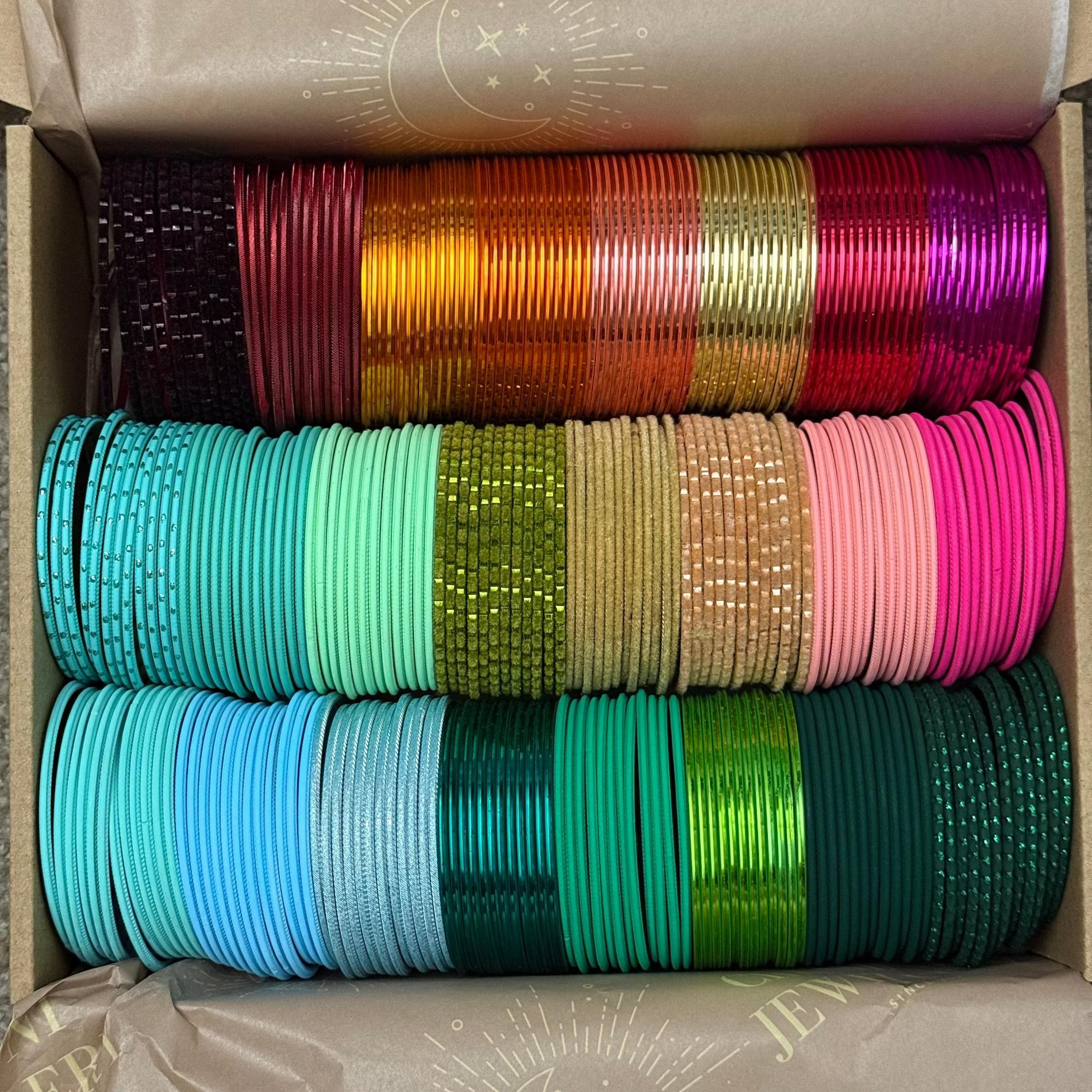 Box containing colorful bangles stacked in rows.