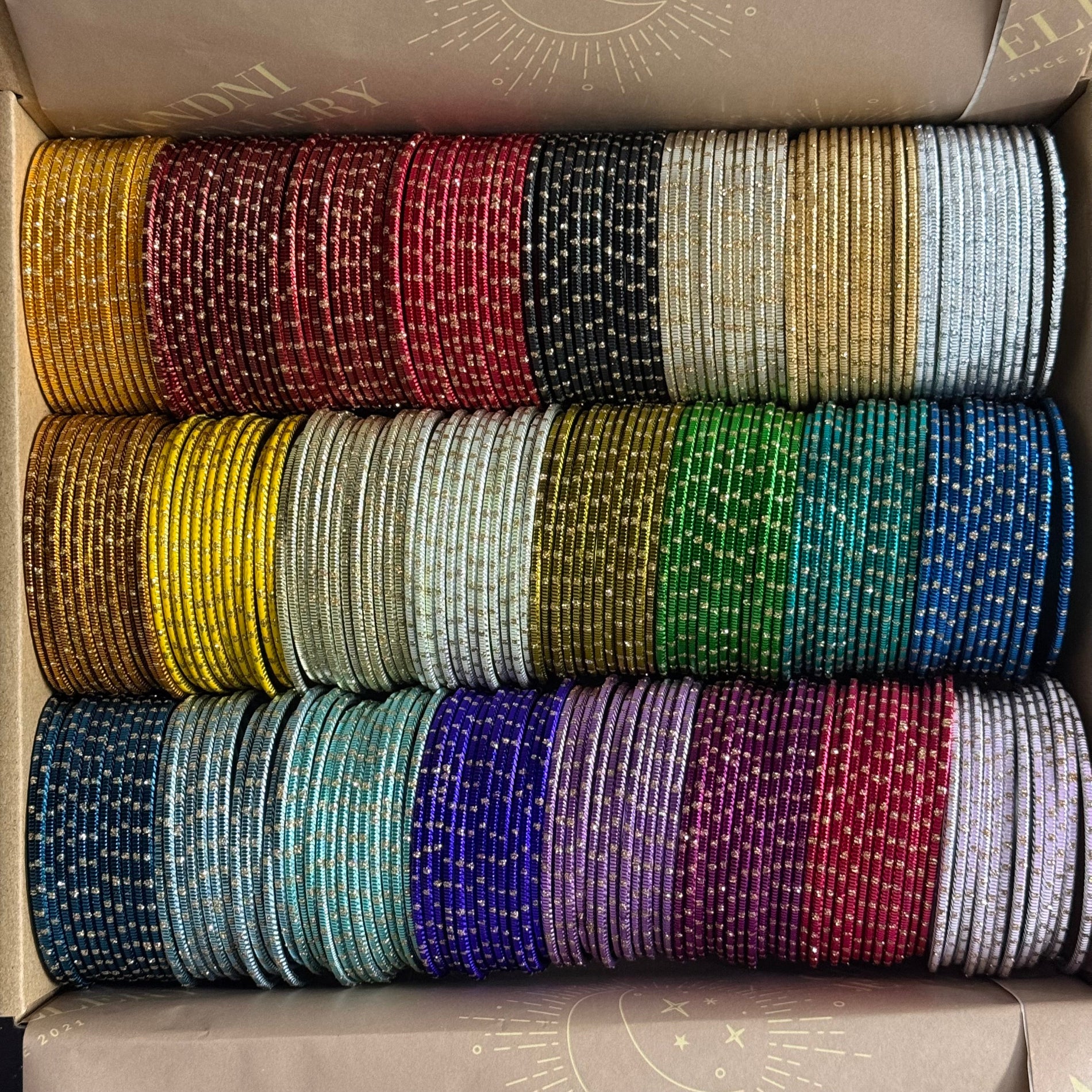 Box containing multiple rolls of colorful bangles