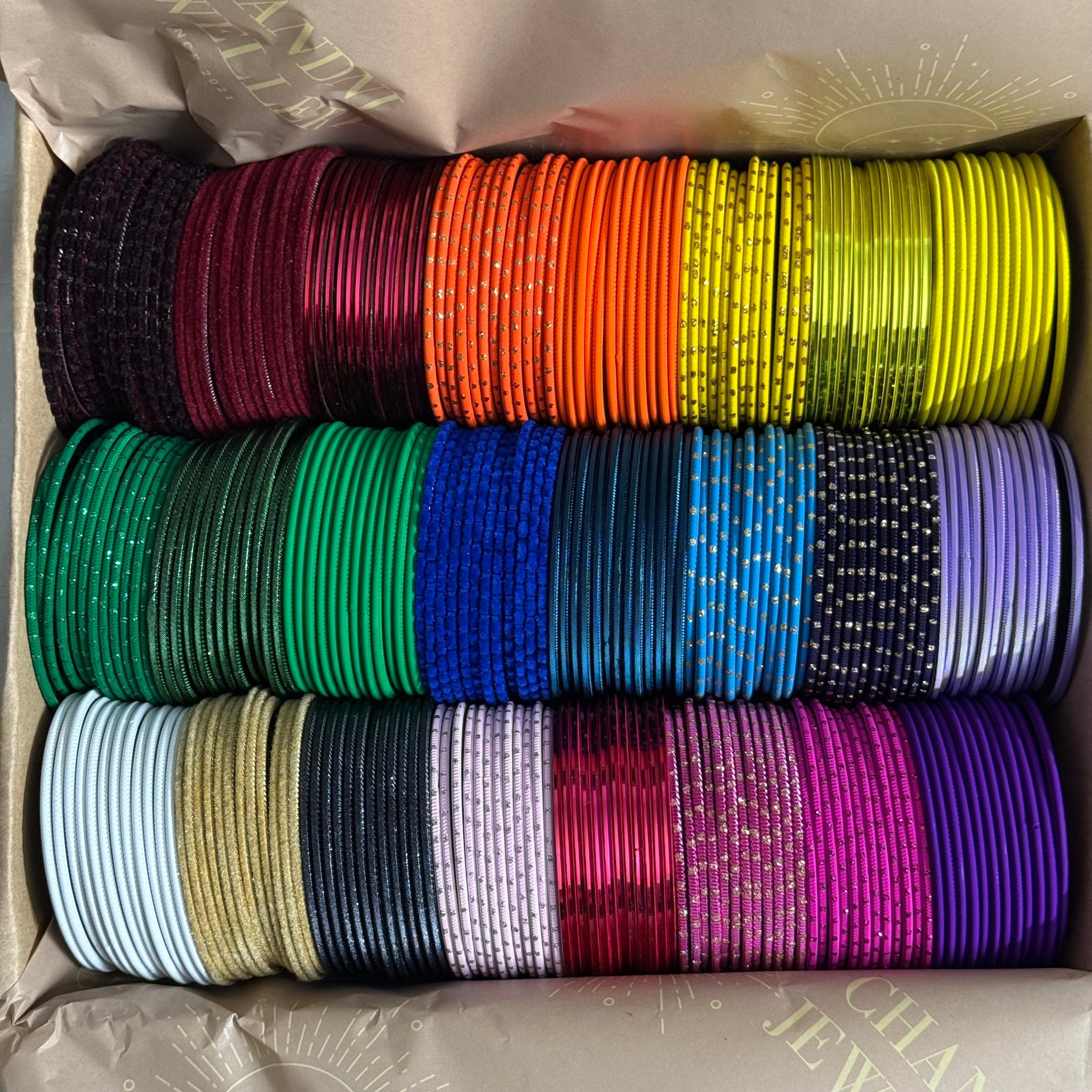 Box containing colorful bangles stacked in rows.