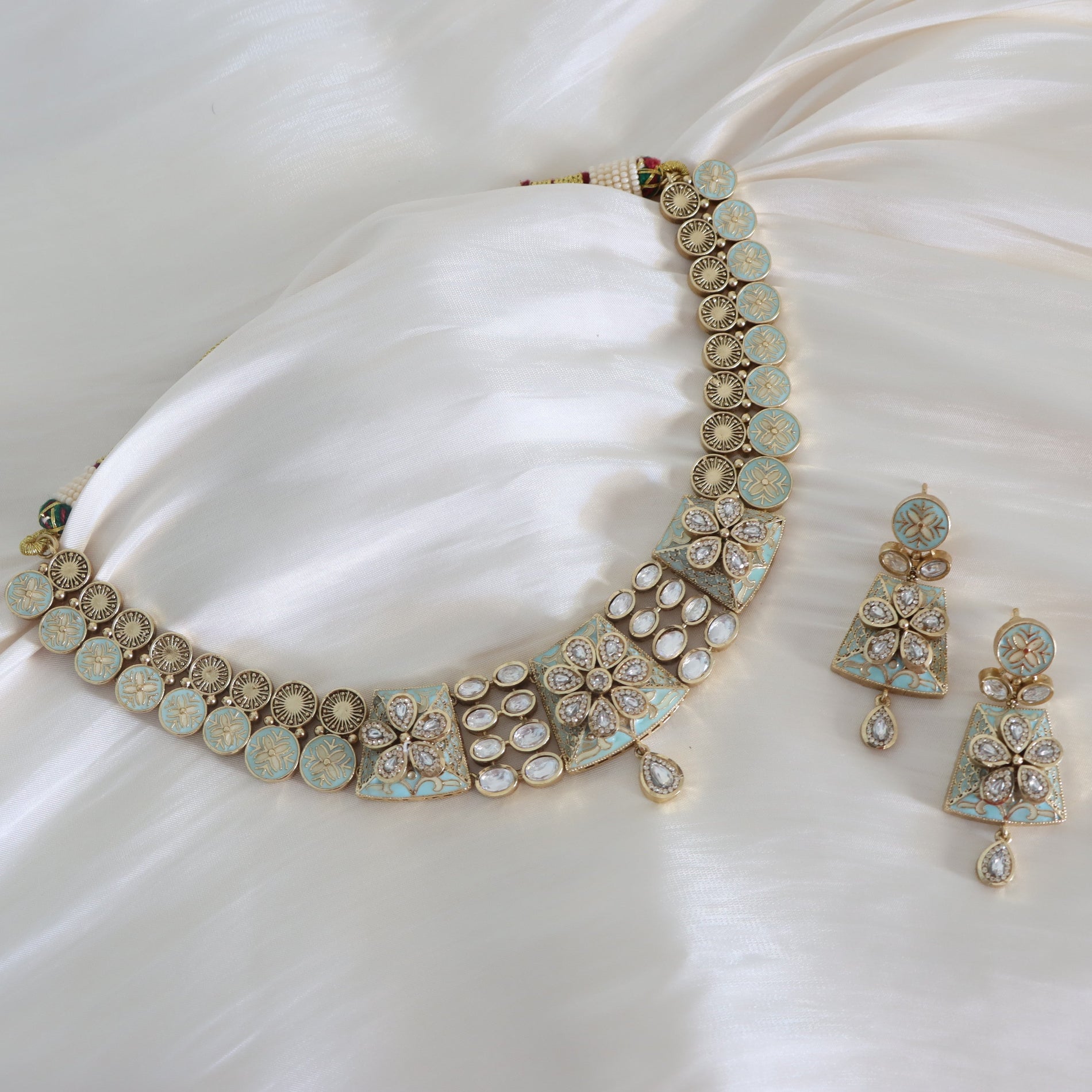 Necklace and earrings set on a white fabric background