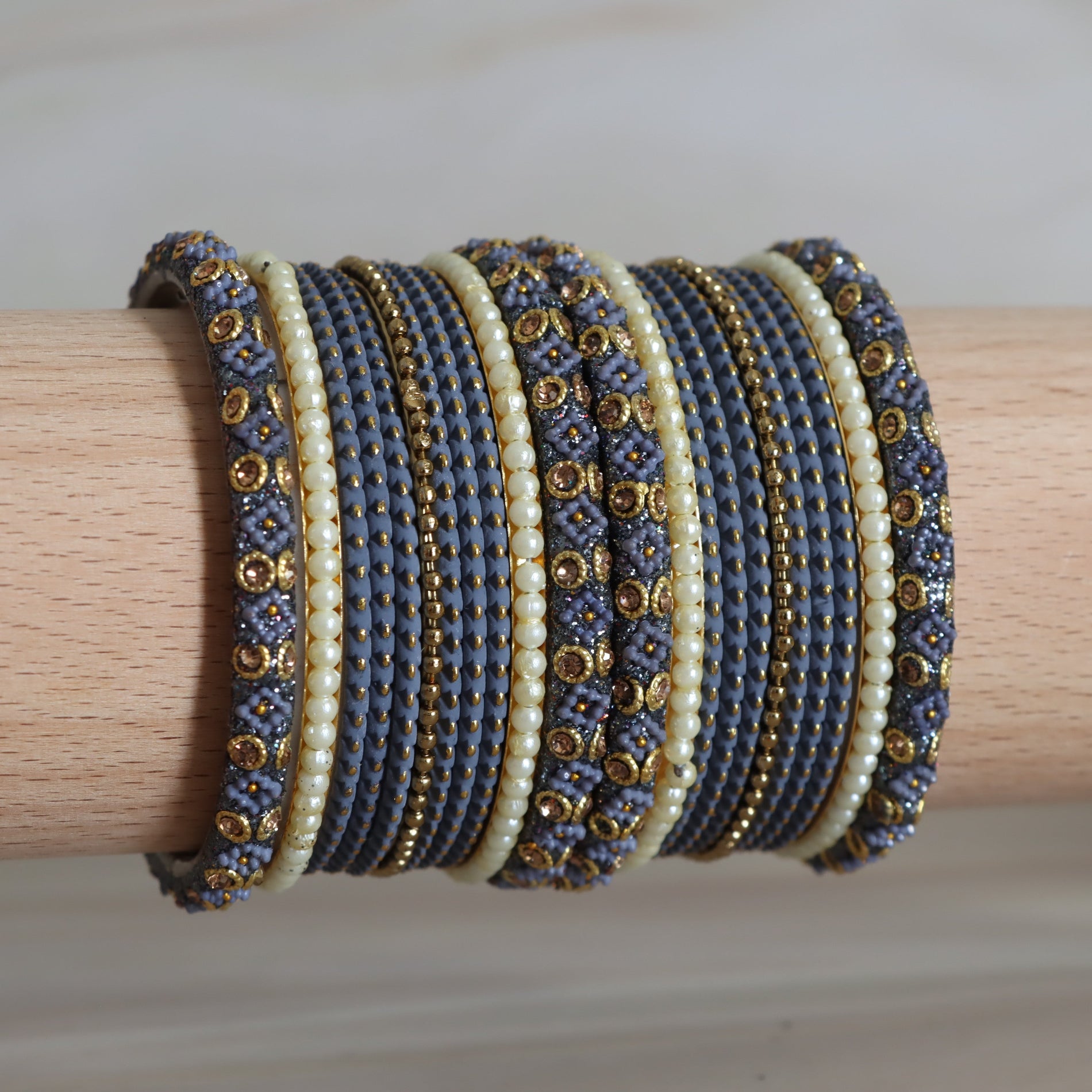 Set of beaded bracelets on a wooden stick with a neutral background