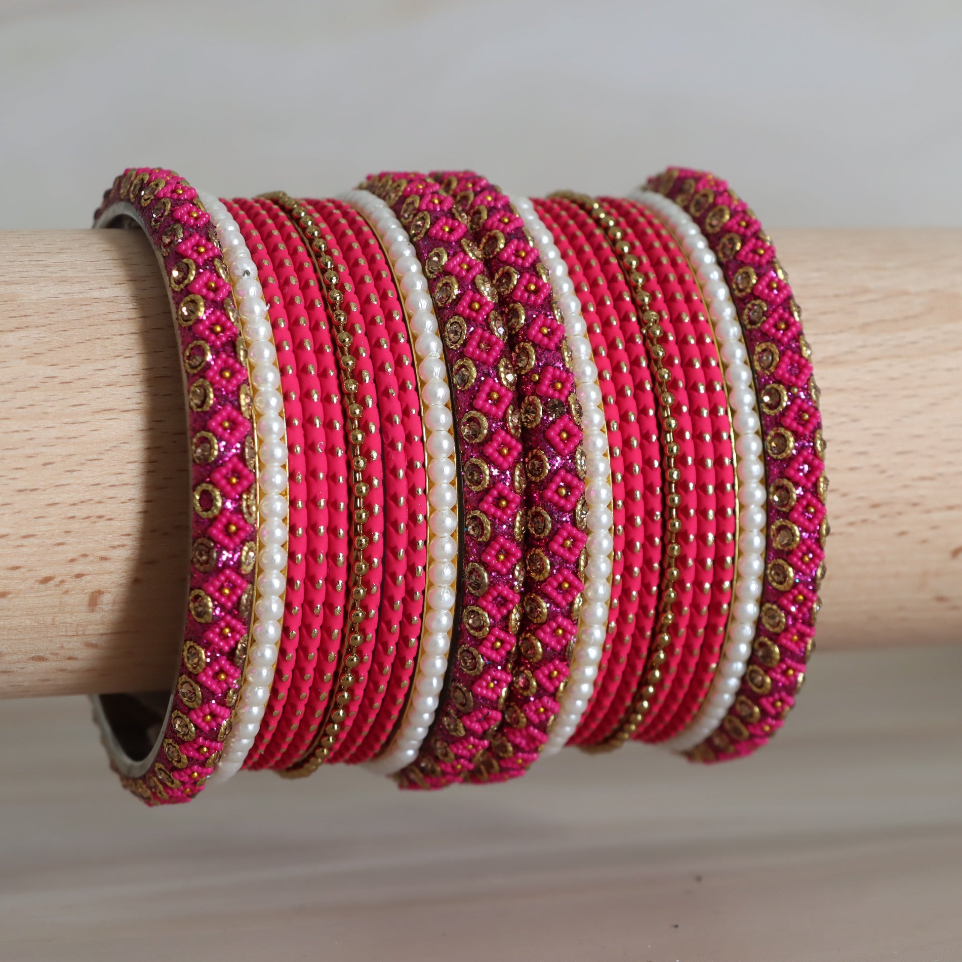 Set of pink and white beaded bracelets on a wooden stick
