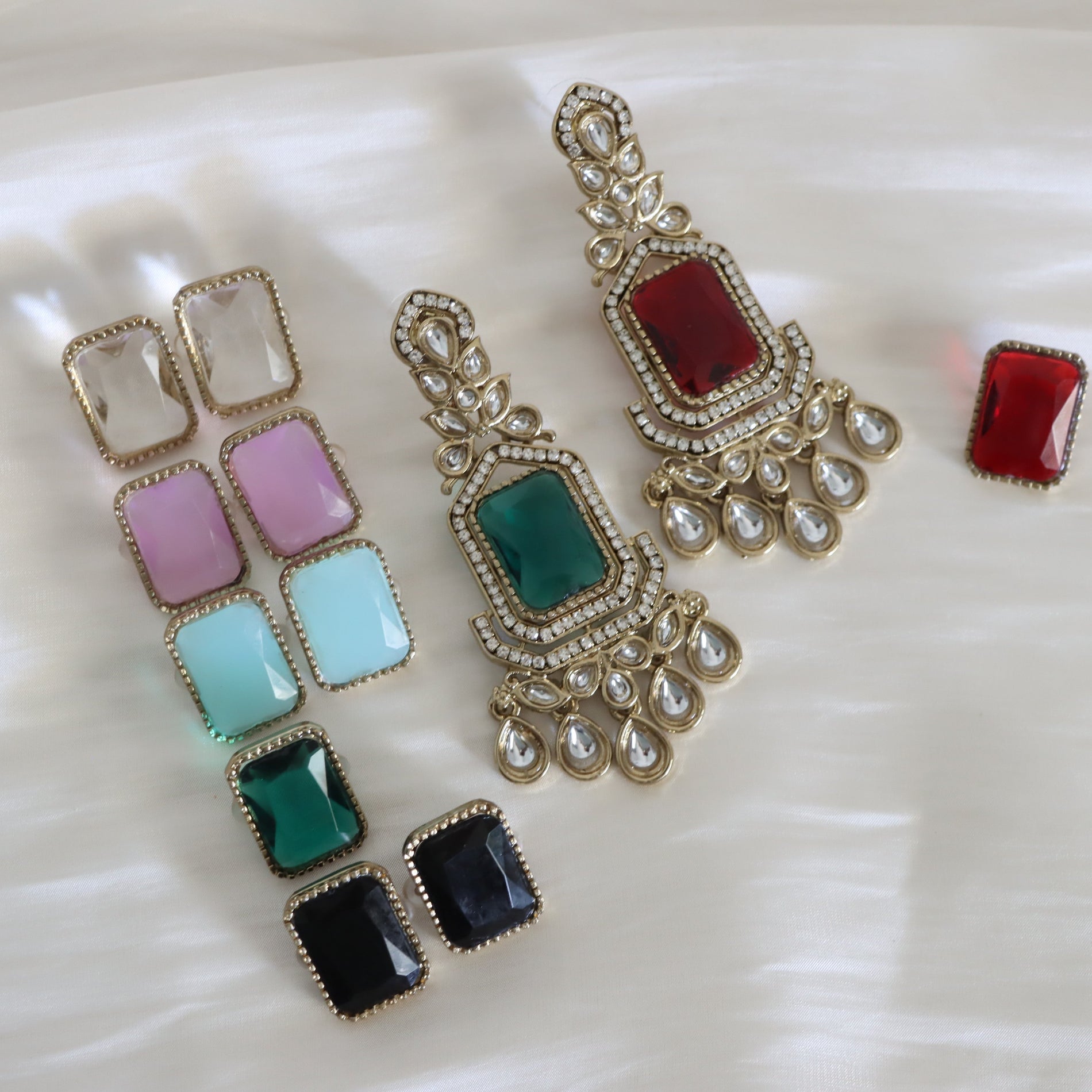 Colorful gemstone earrings on a white surface
