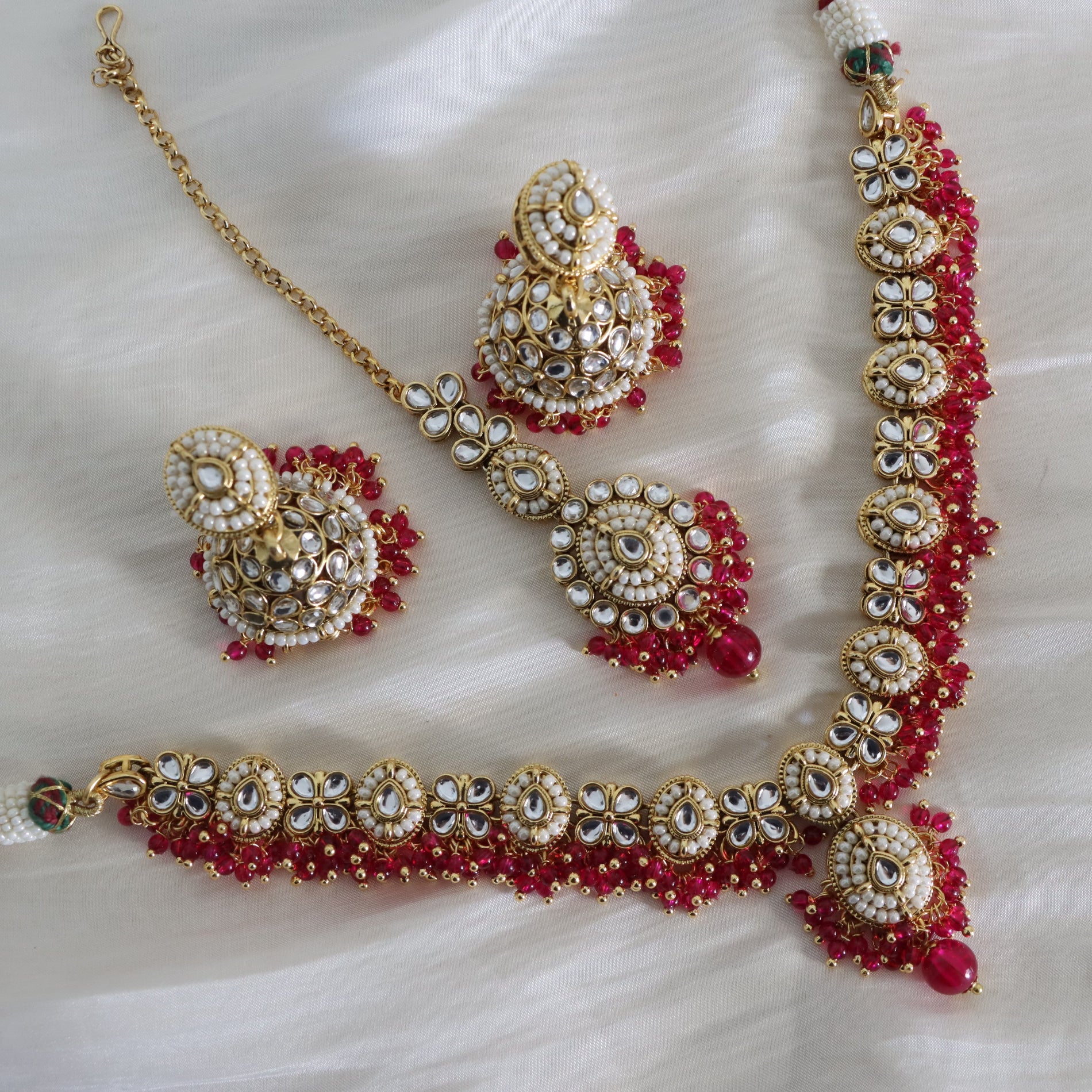 Jewelry set with necklace, earrings, and bracelet on a white background