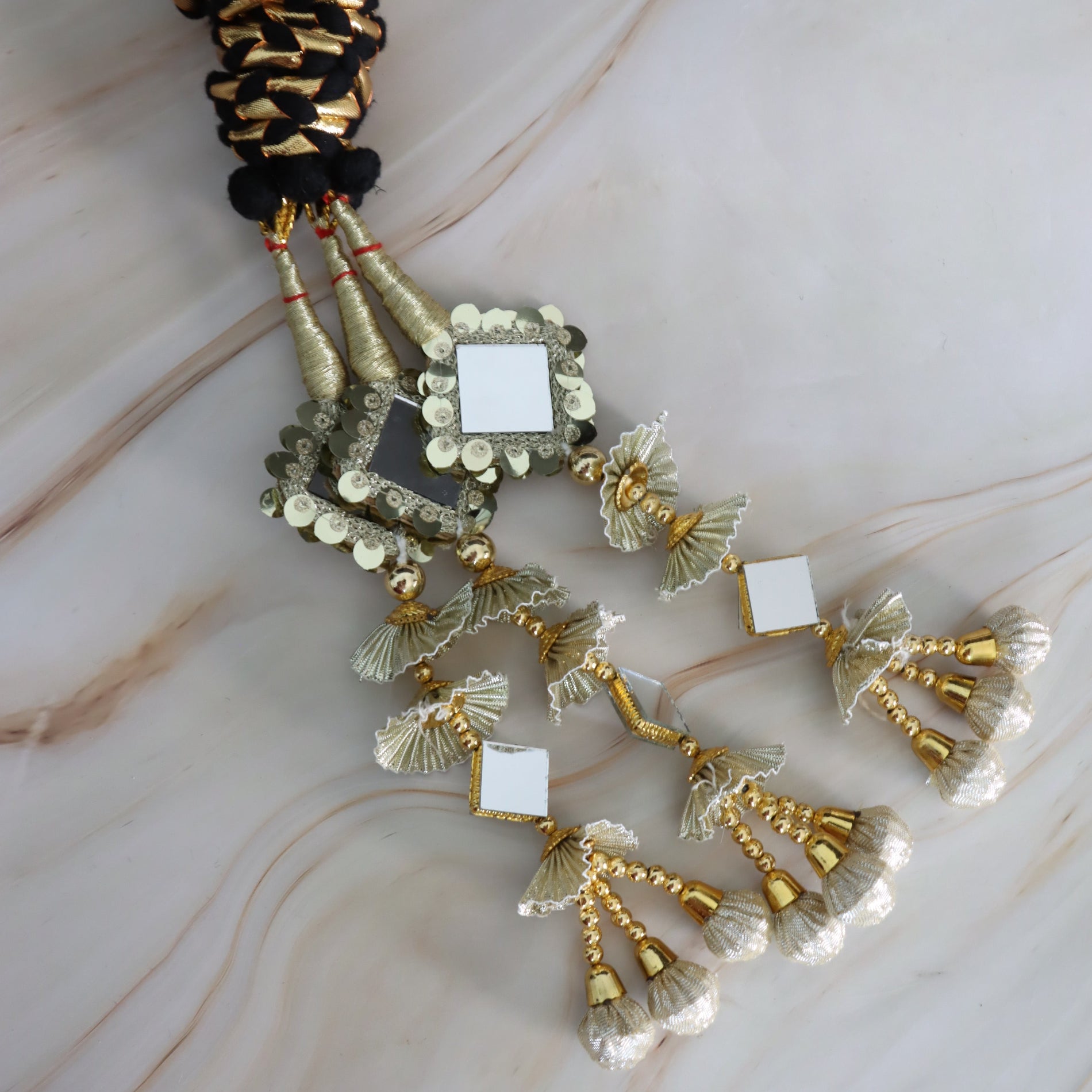 Decorative hair accessories with gold and black details on a marble surface