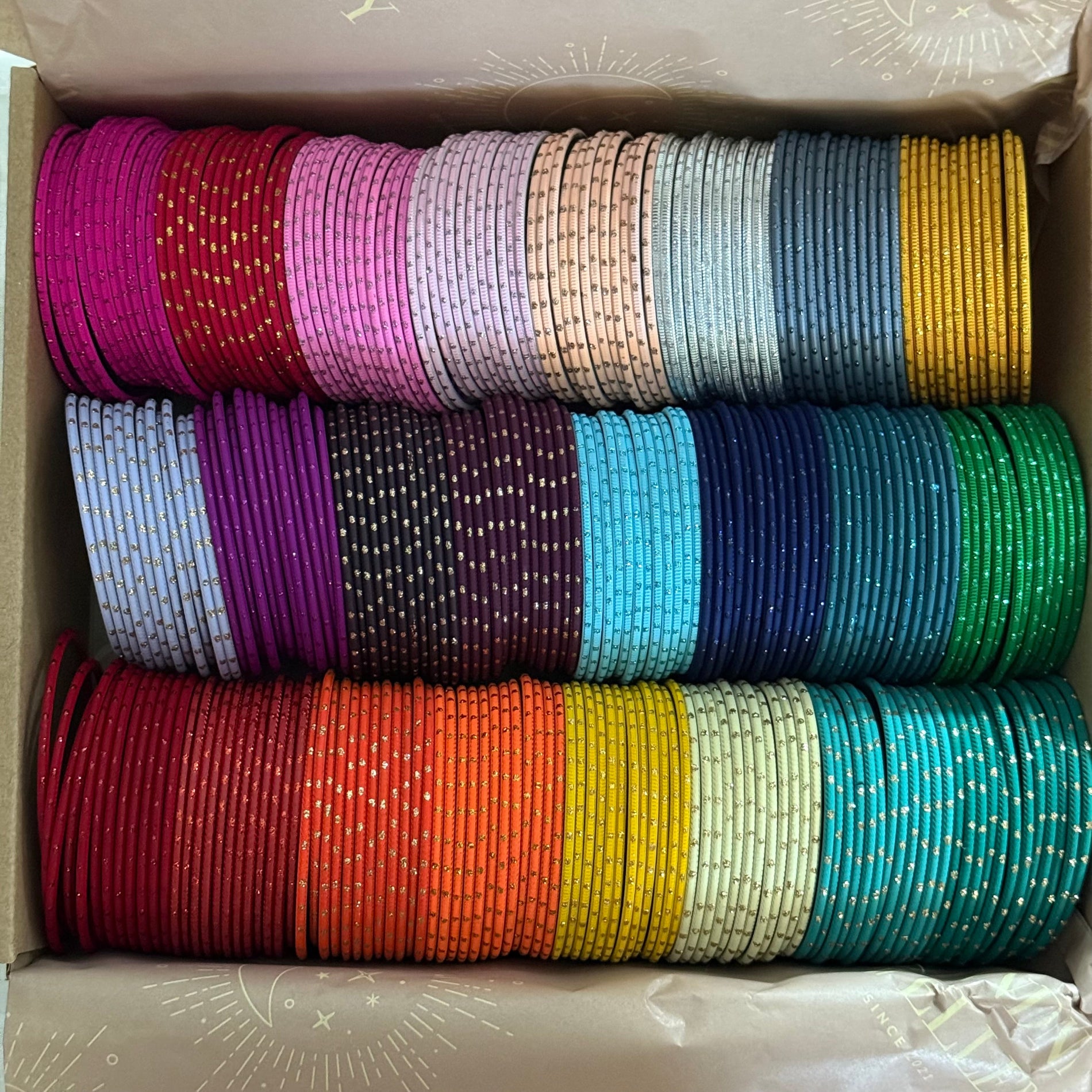 Box filled with colorful bangles stacked in rows.