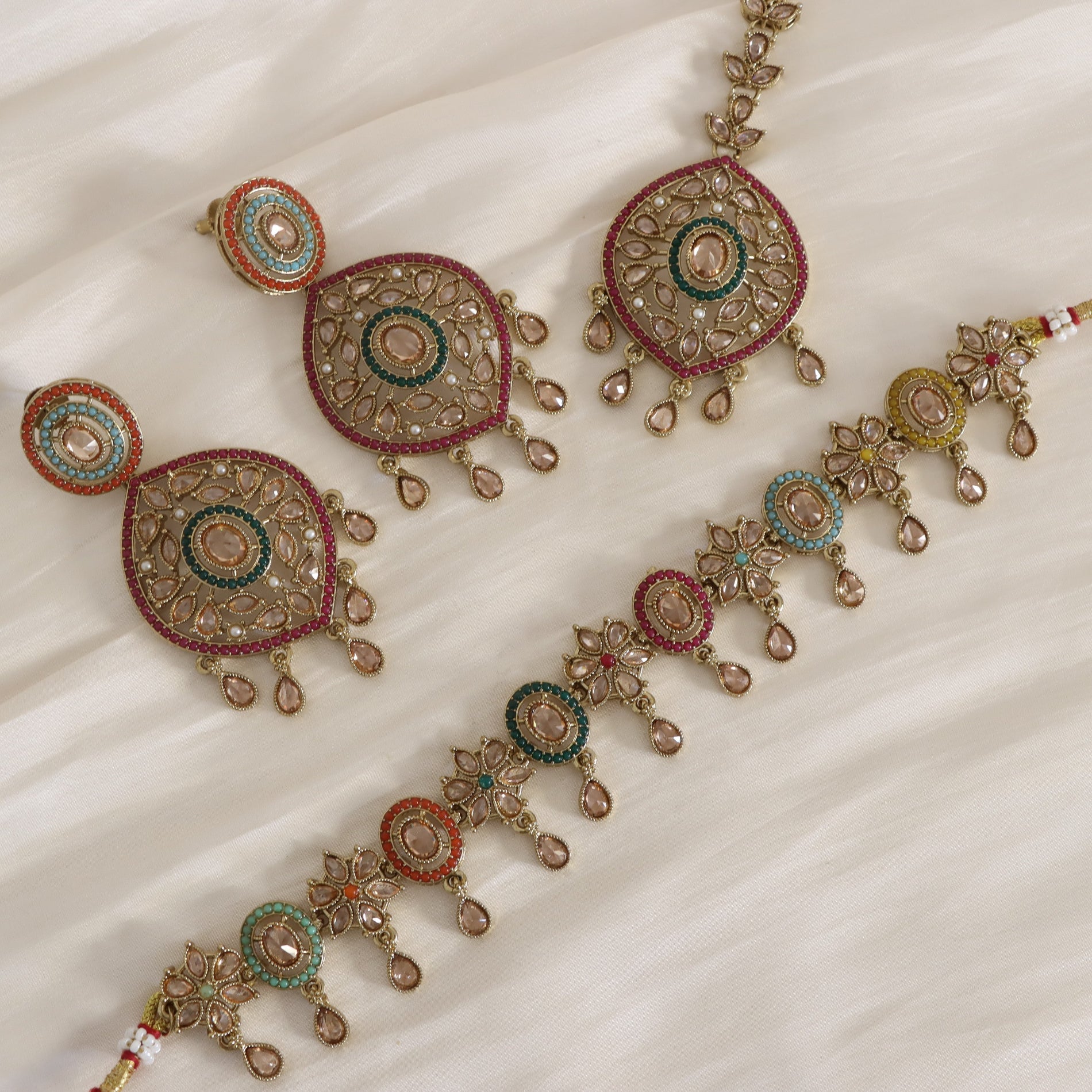 Ornate jewelry set on a white fabric background