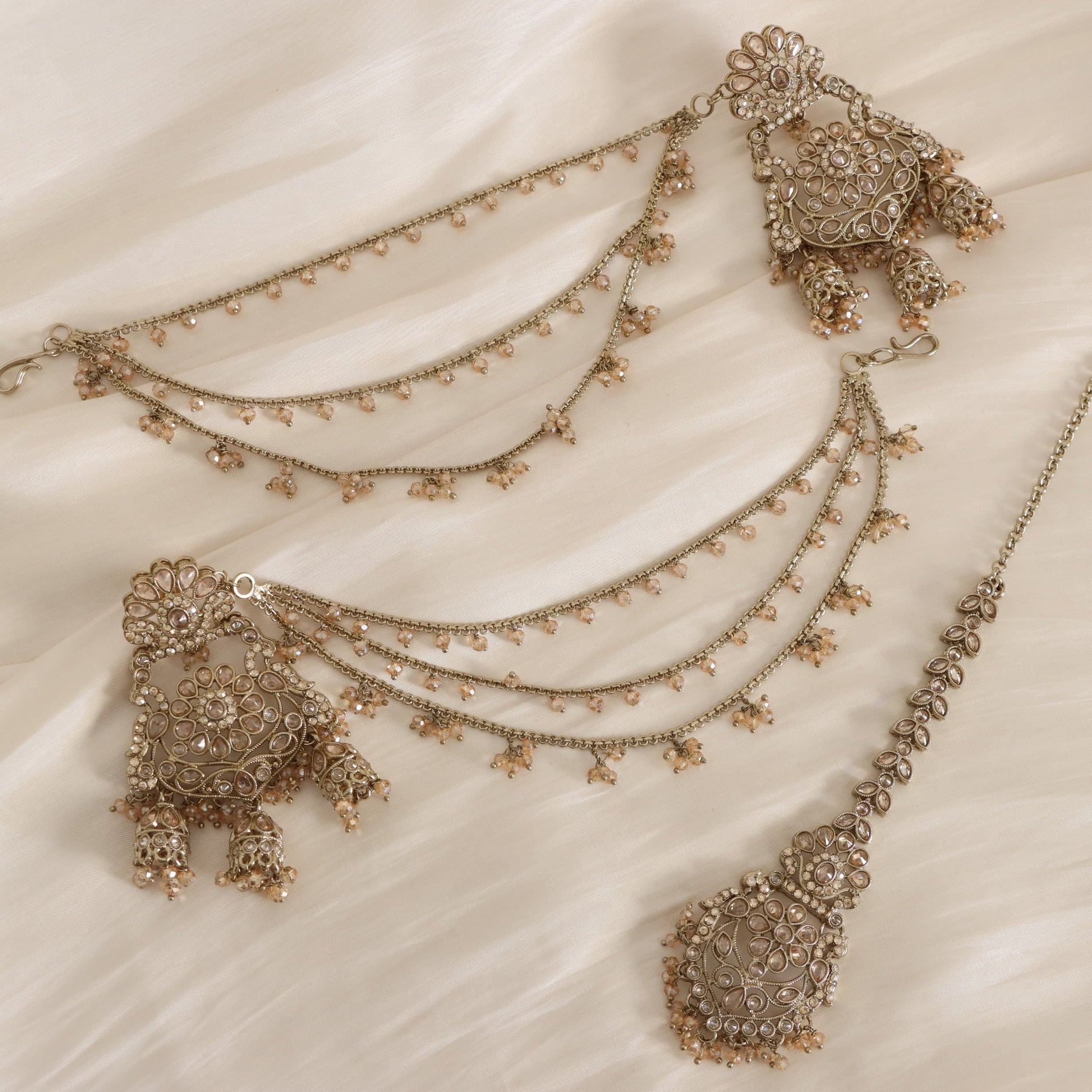 Decorative necklace with intricate designs on a beige fabric background