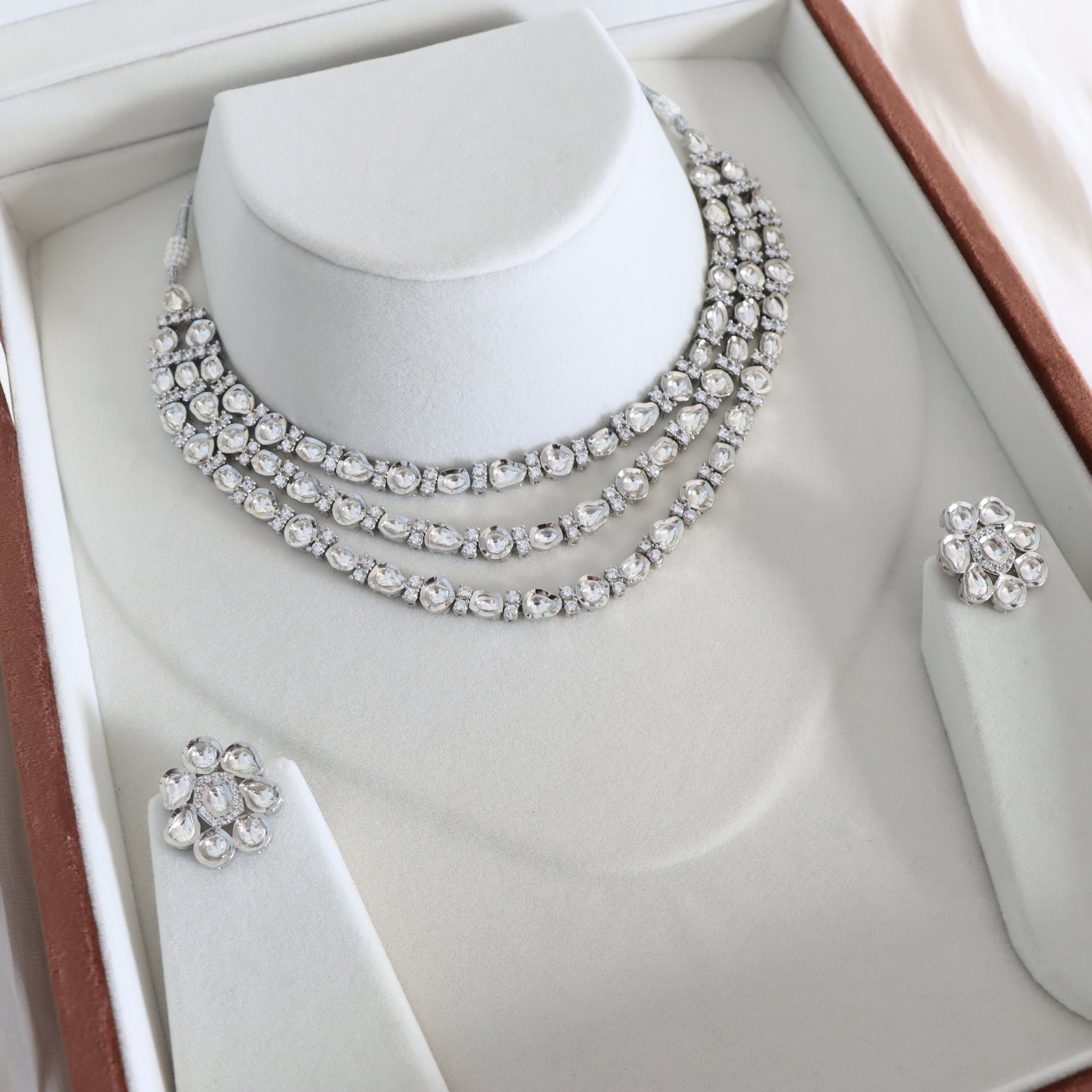 Jewelry set with necklace and earrings on a mannequin bust in a box